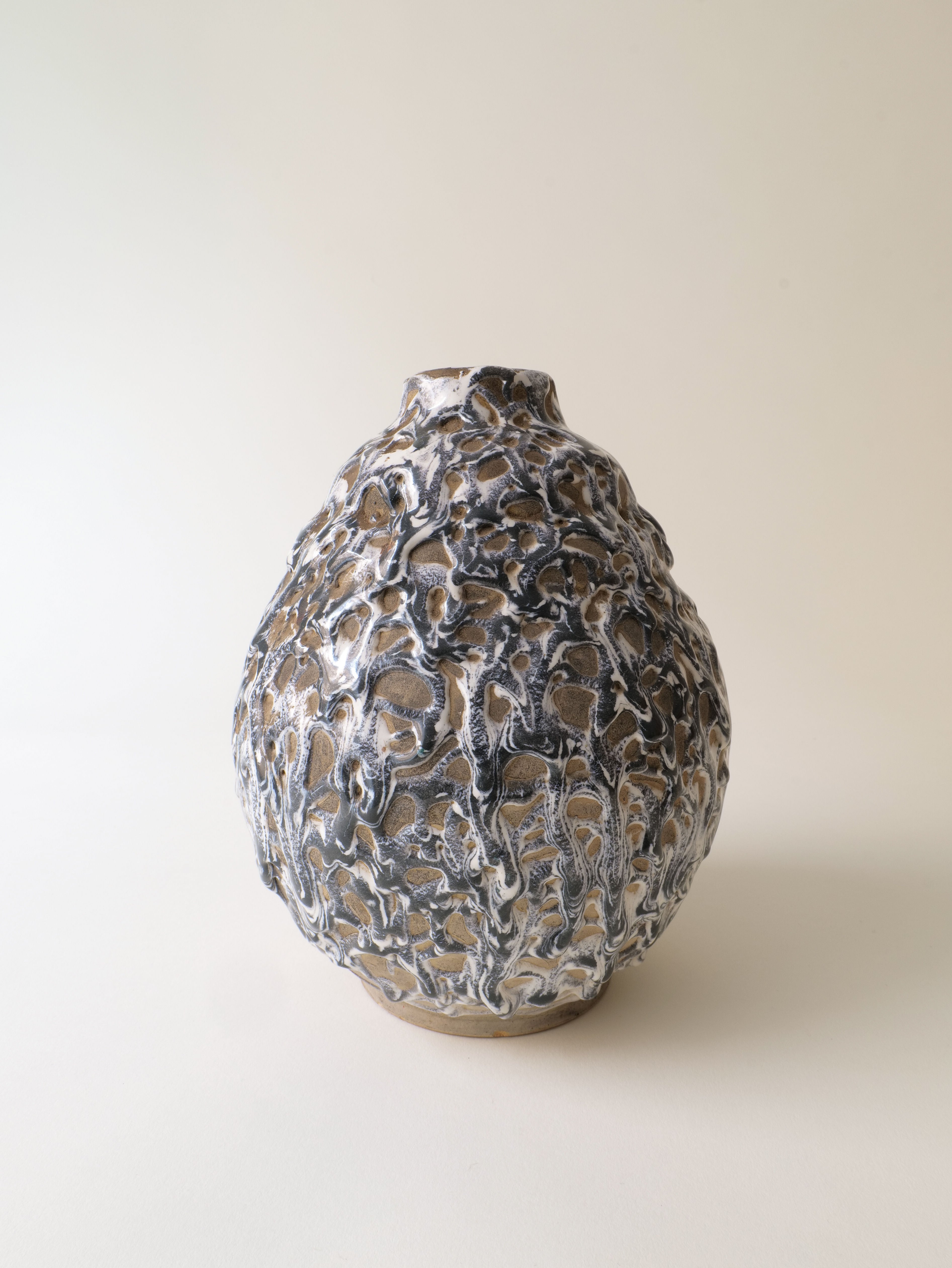 The Deco Ceramic Vase 1930s by Collection apart features a round stoneware shape with a textured, organic surface in brown, white, and gray tones, evoking Alfred Renoleau’s artistry. It is displayed on a plain light background.
