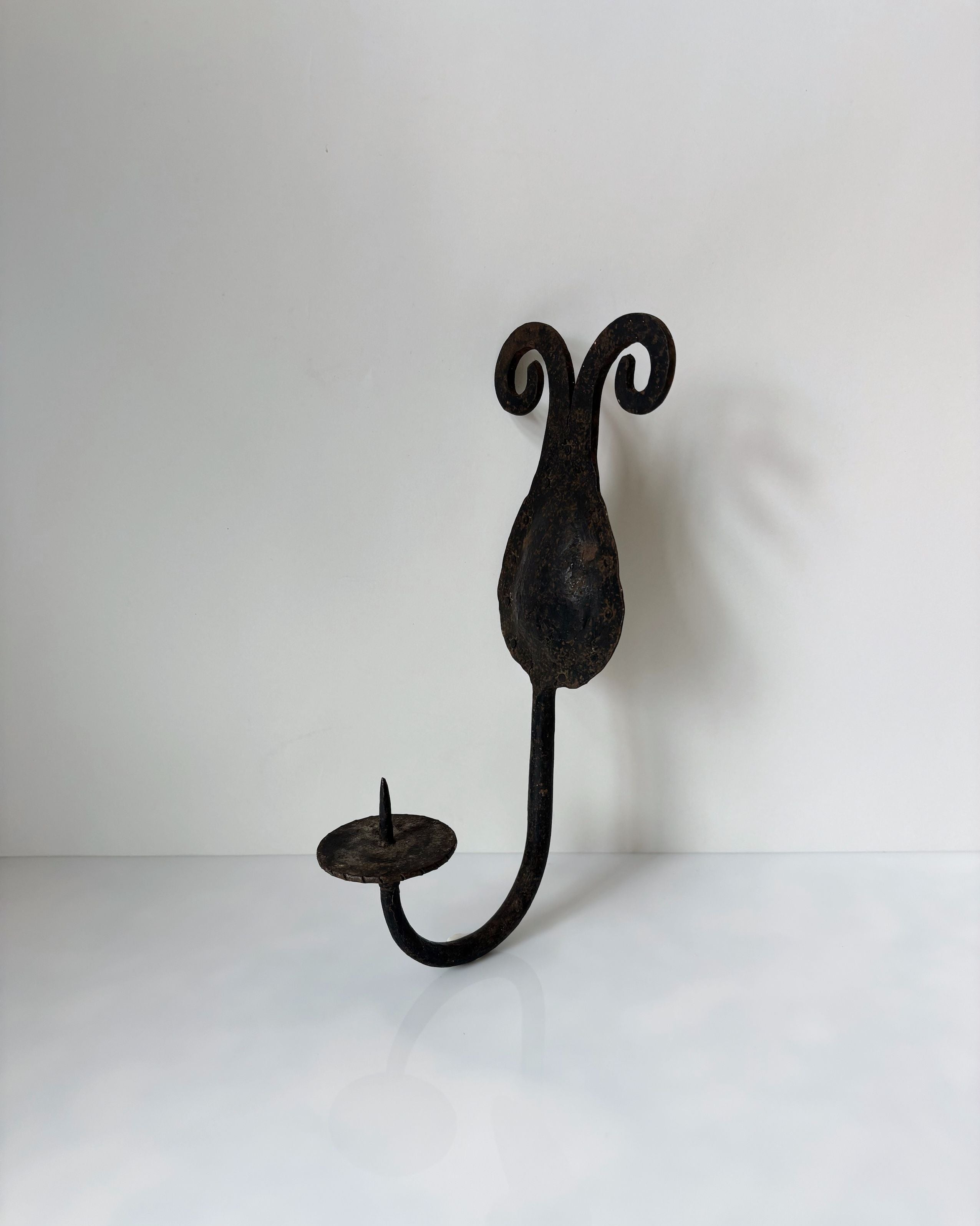 Hand-forged iron wall sconce with decorative scrollwork from Poland