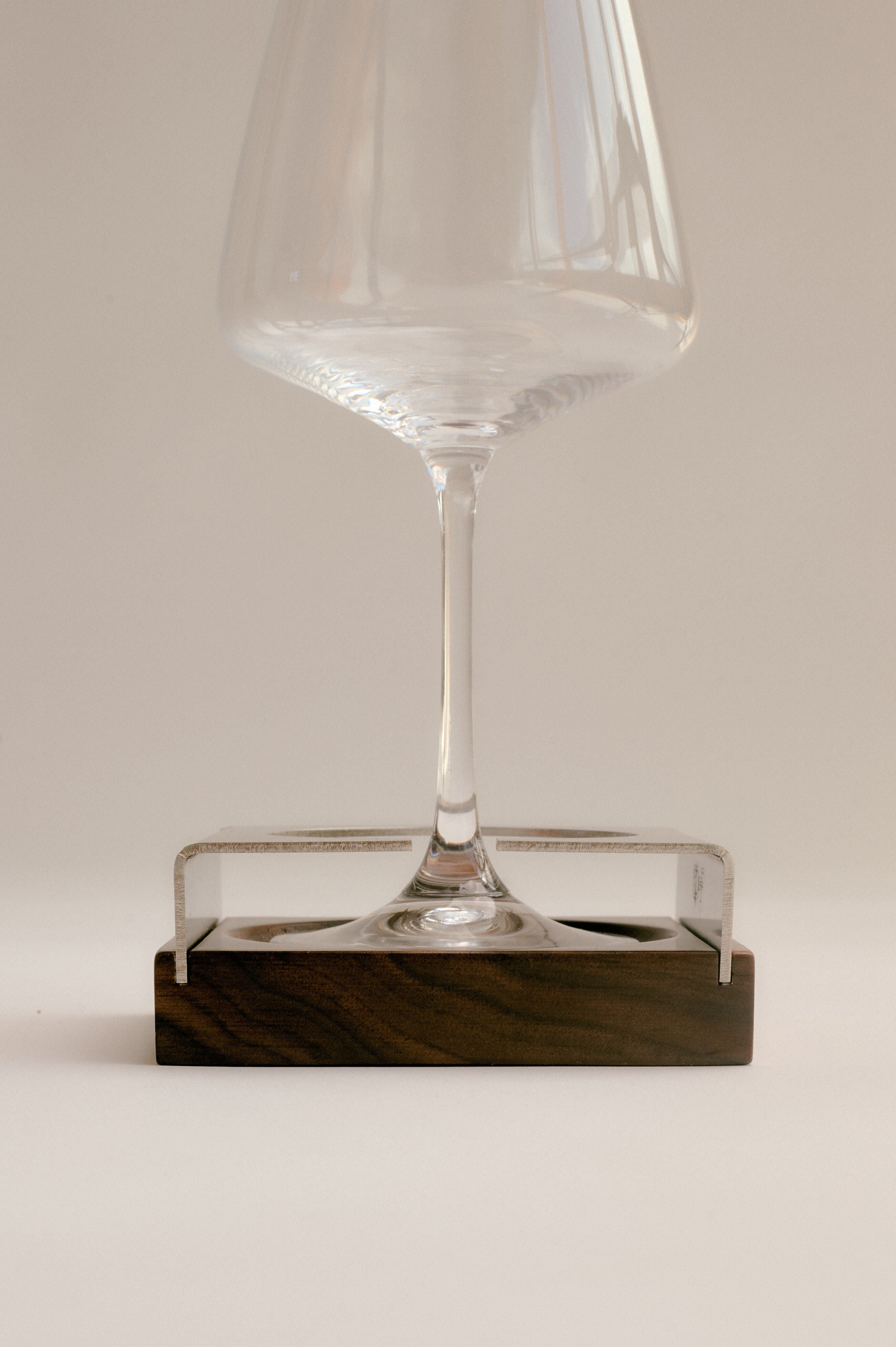 Clear acrylic coaster with wine glass on walnut wood base