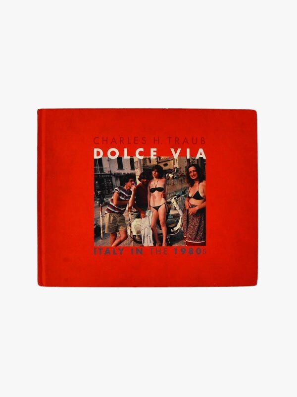 A photography collection cover titled "Dolce Via: Italy in the 1980's" by Charles H. Traub, depicting lively street scenes in Italy during the 1980s with people in casual summer attire. The cover is by Maison Plage.