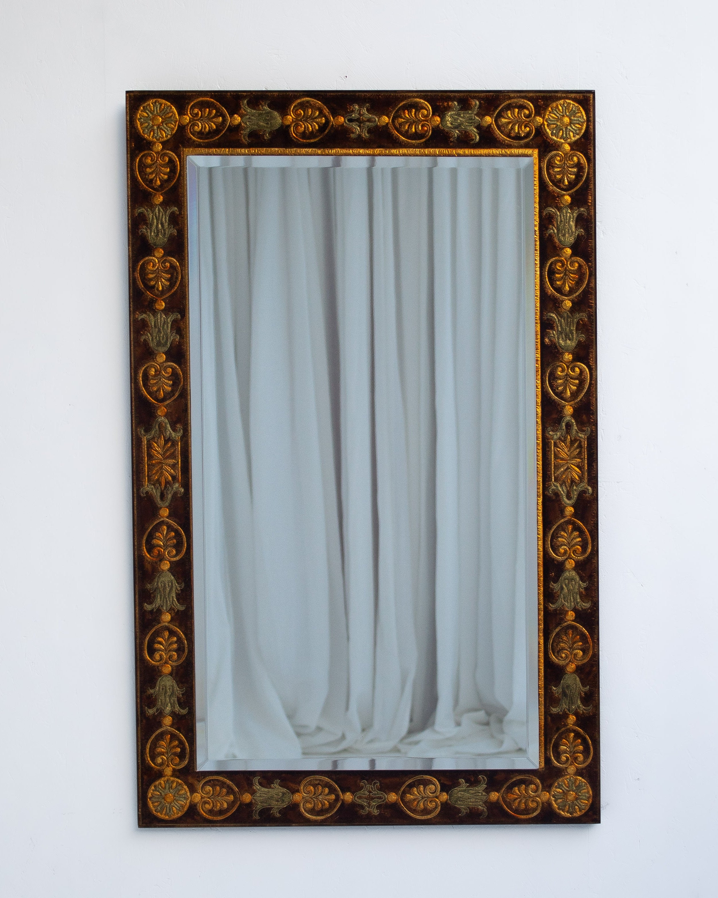 Ornate dark wood wall mirror with golden decorative motifs