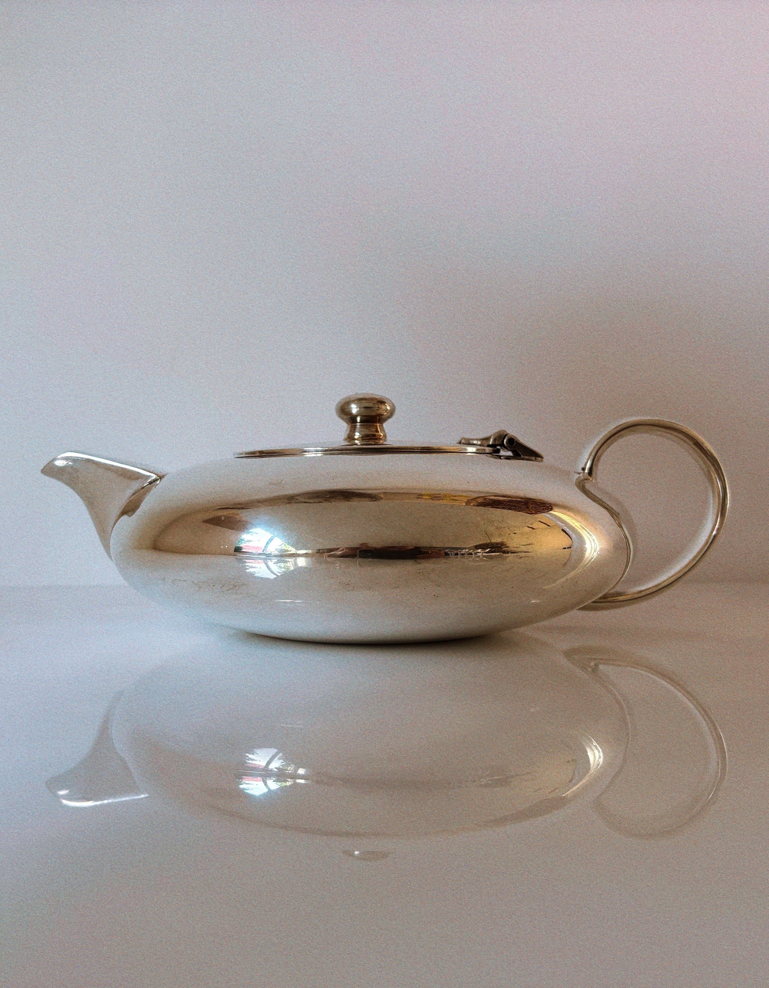 Elegant silver plated teapot with curved spout and reflective finish