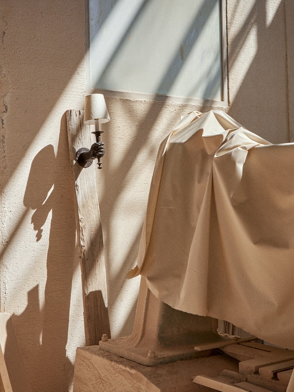 Hand-Torch Wall Light — close-up of wall-mounted fixture with shadow detail