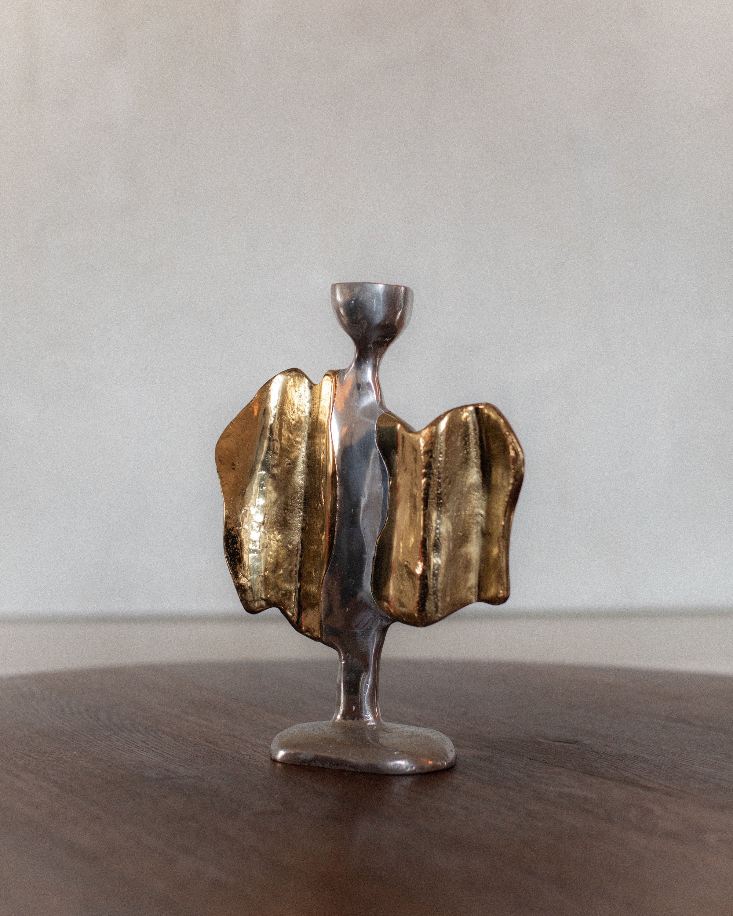 Sculptural brass and pewter candleholder with flowing metallic form