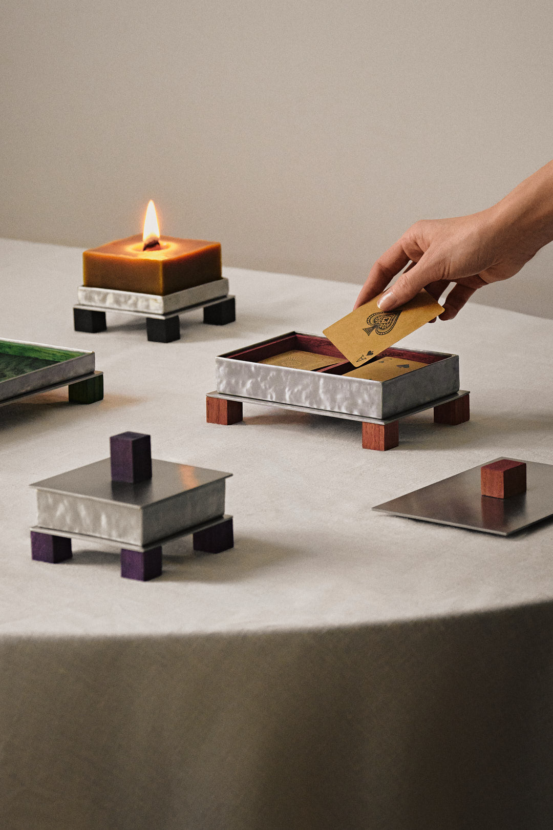 Modern card box with metallic finish and wooden legs on marble surface