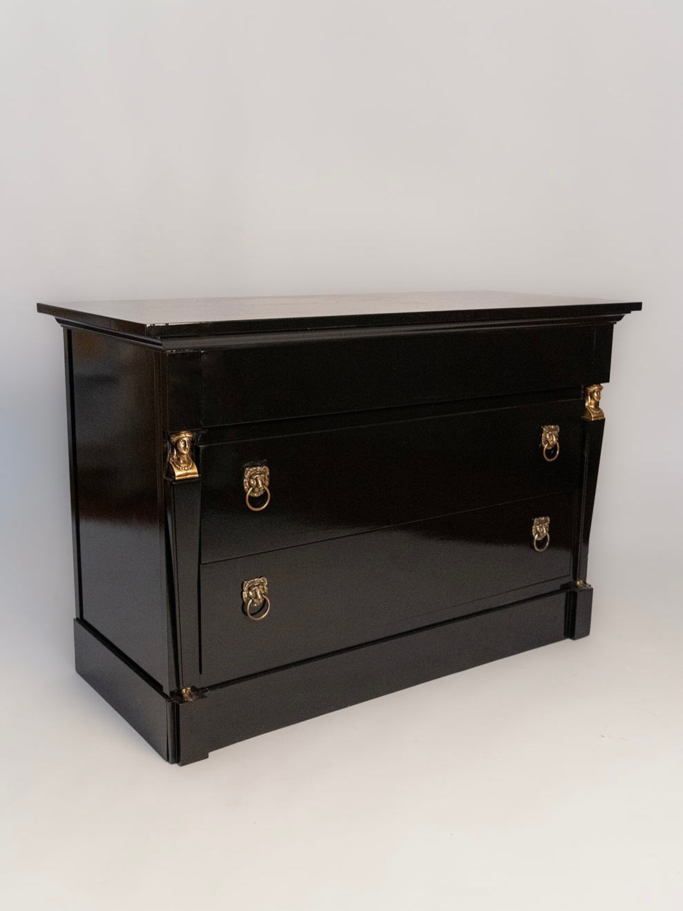 The 'Return of Egypt' Lacquered Drawers by Barracuda Interiors features two spacious drawers, gold ring pull handles, and corner accents, echoing 19th-century French elegance against a white backdrop.