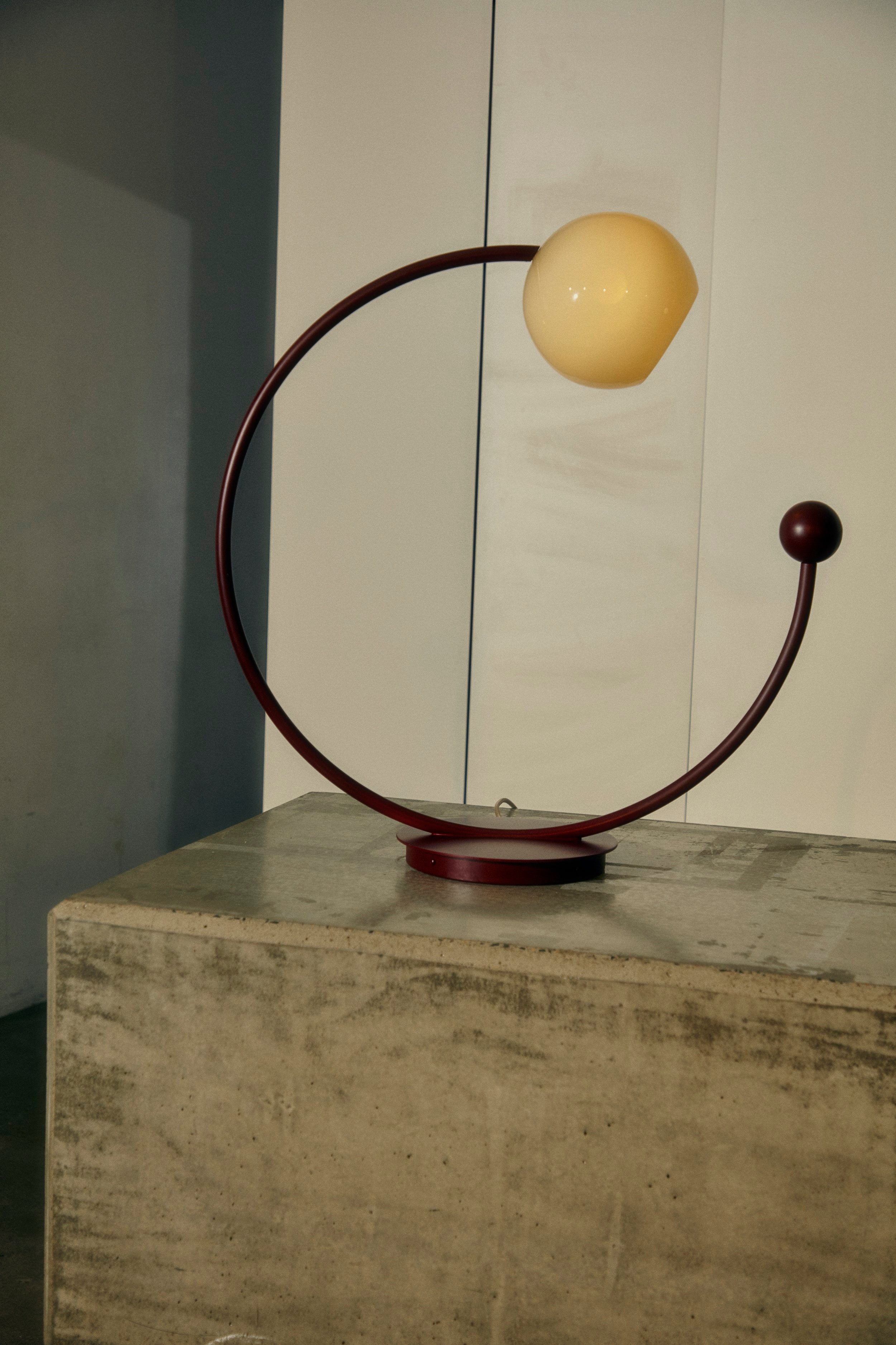 Oro Table Lamp w/ Handblown Glass — angled view on concrete surface