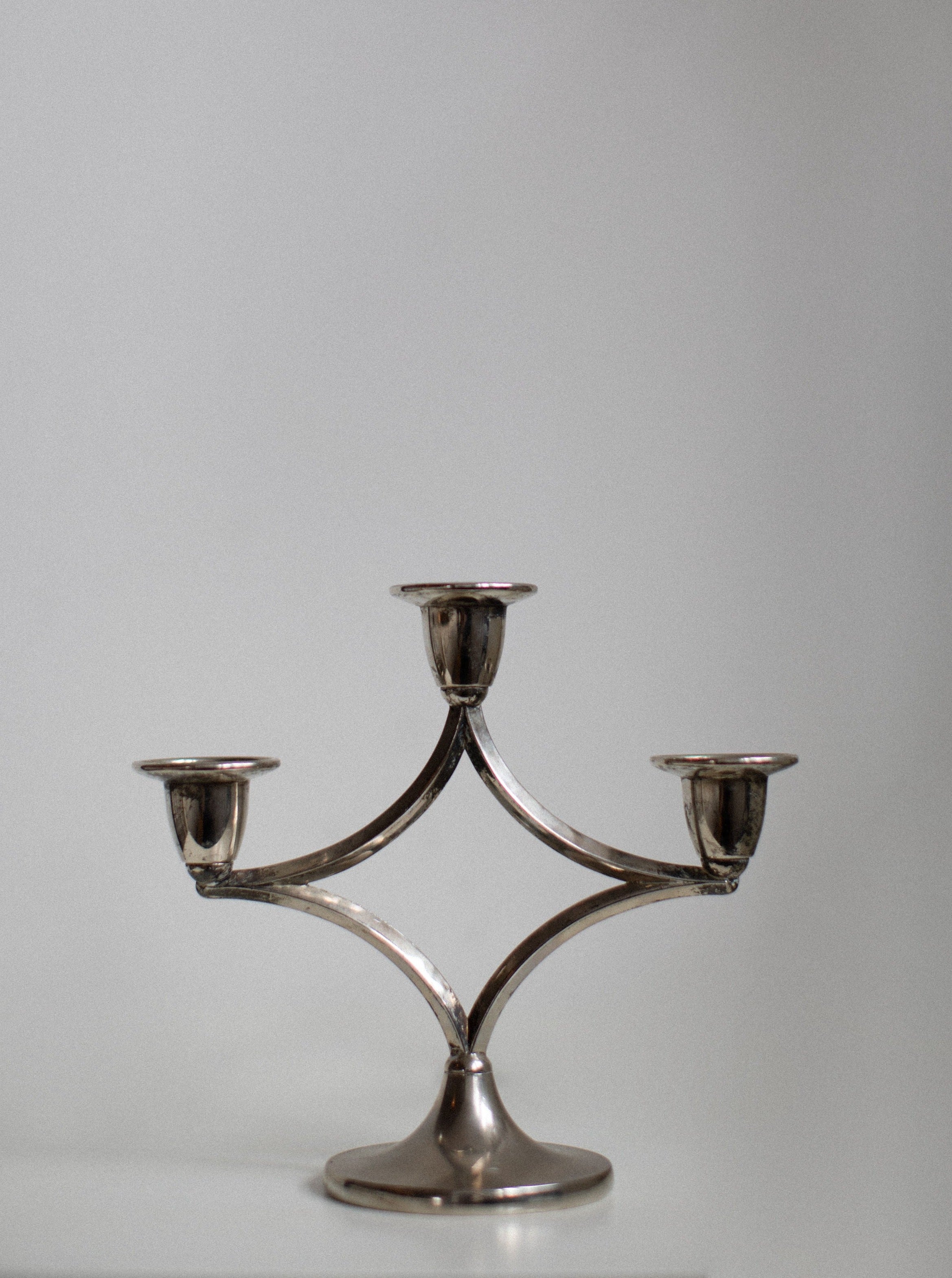 Silverplated Candleholder featuring intricate floral design and elegant curves