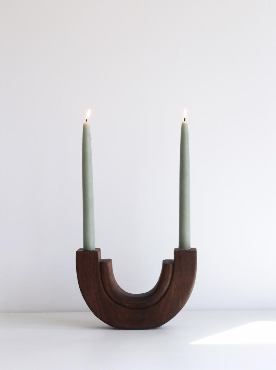 Alt text: Elegant and modern half circle candle holder made of sleek metal