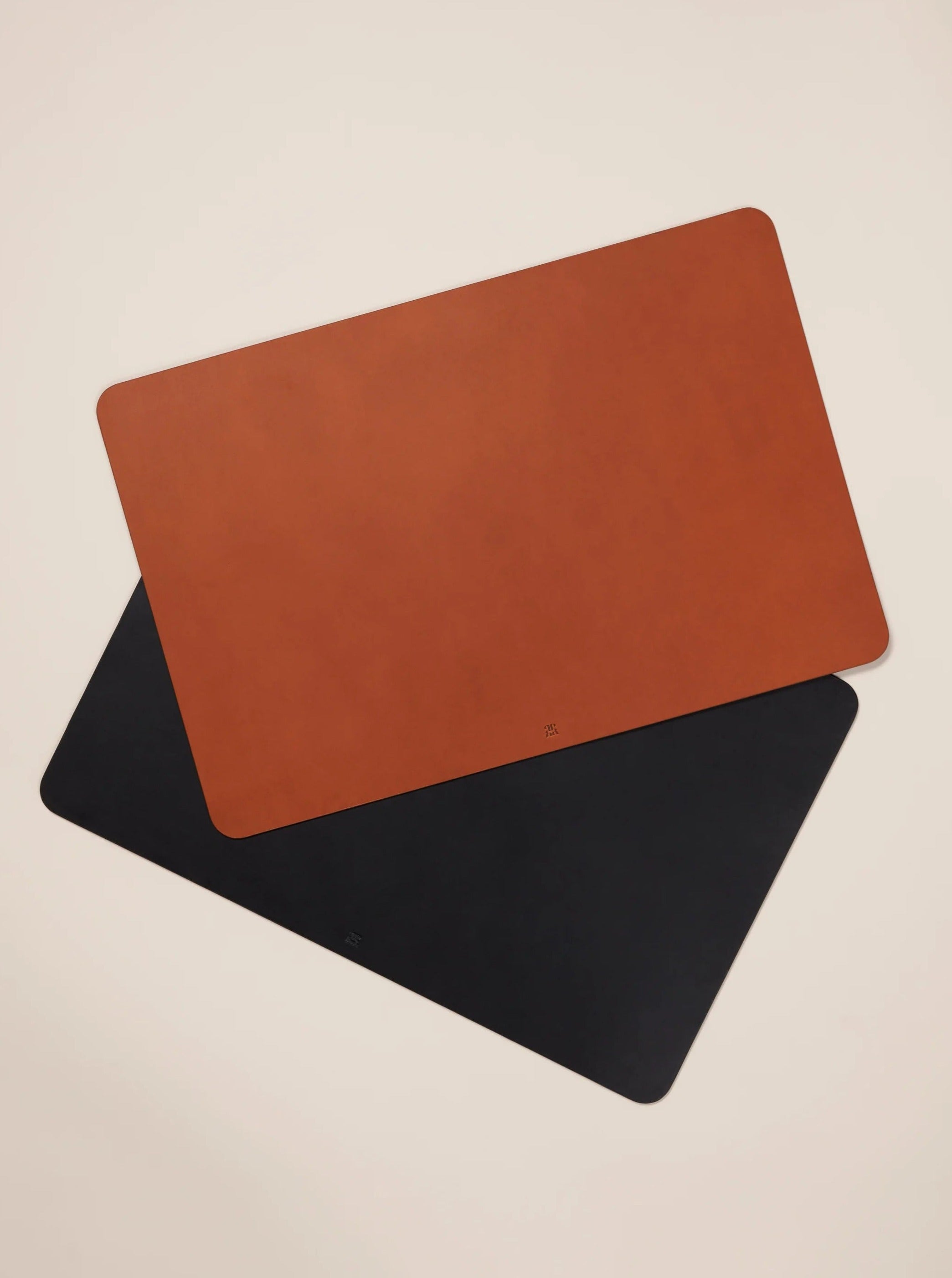 Black leather desk mat with stitching detail and smooth finish