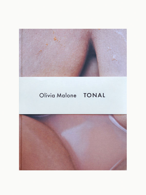A book cover featuring a close-up photograph of the female form with subtle skin textures. It includes the text "Maison Plage Olivia Malone: Tonal" centered on a white band.