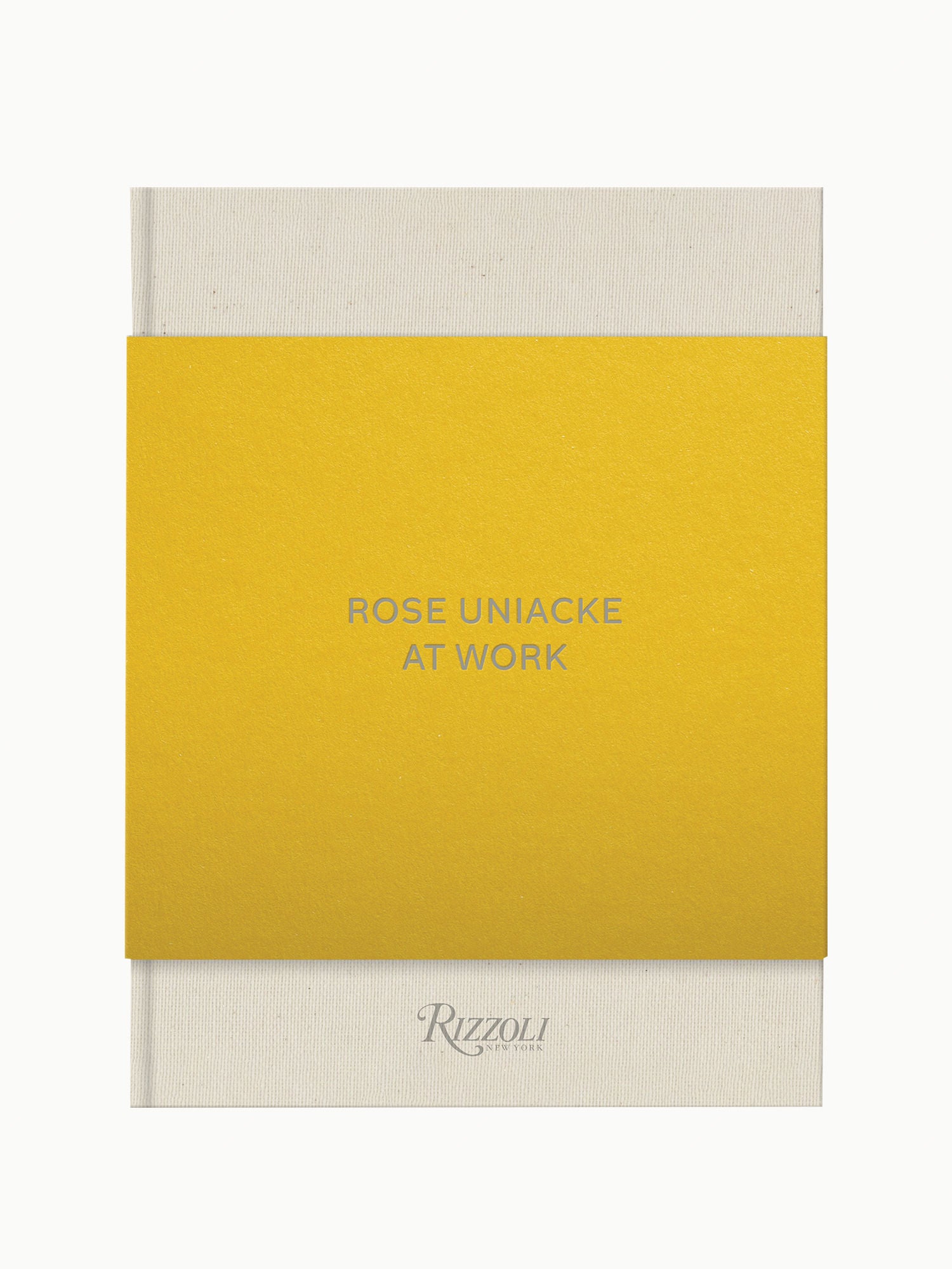 A book cover with a bright yellow sleeve featuring the text "Rose Uniacke at Work" in black letters, and the publisher's name "Rizzoli" at the bottom, set against a Maison Plage.
