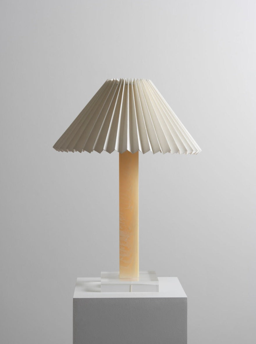 Elegant lamp with crystal base and white linen shade illuminating room corner