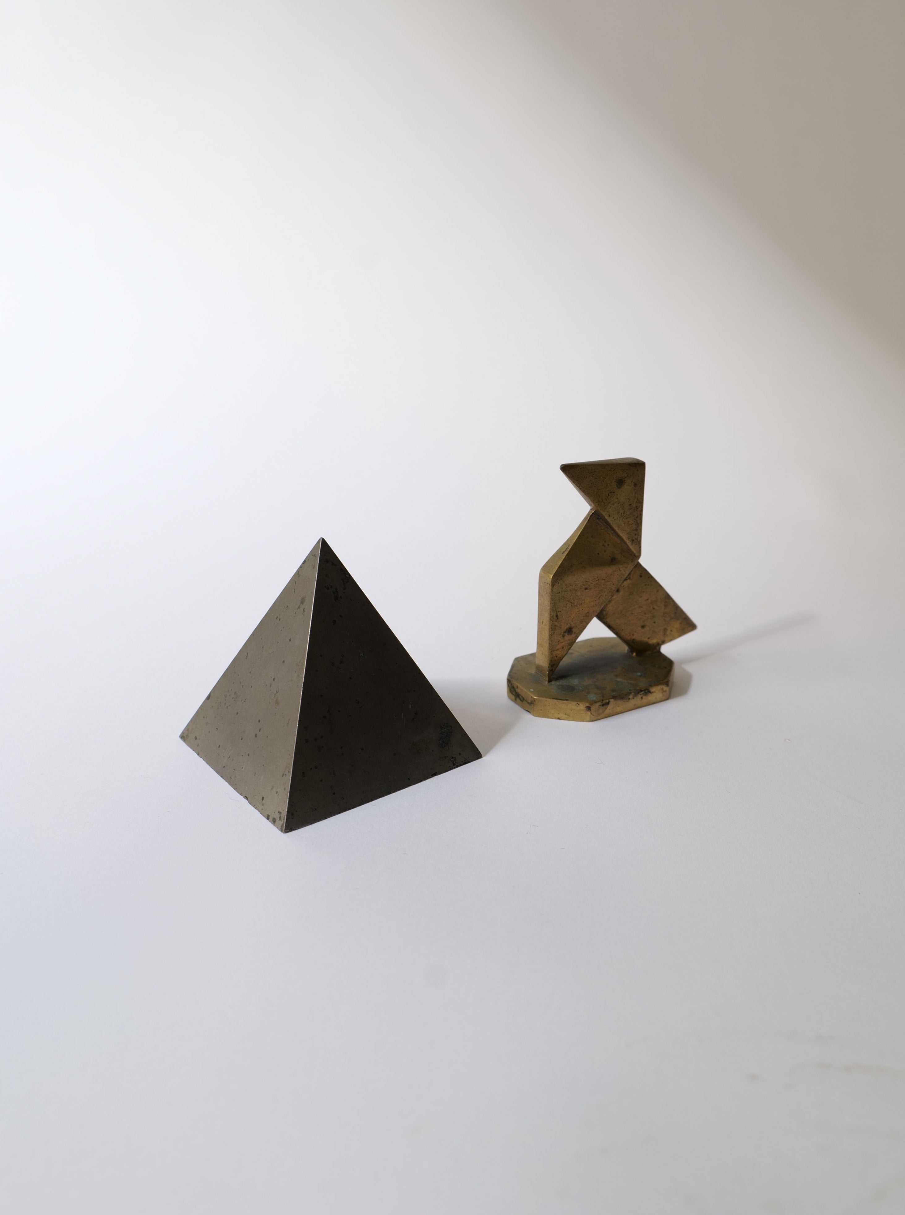 Geometric Paper Weights 1930 in silver and gold finish on white background