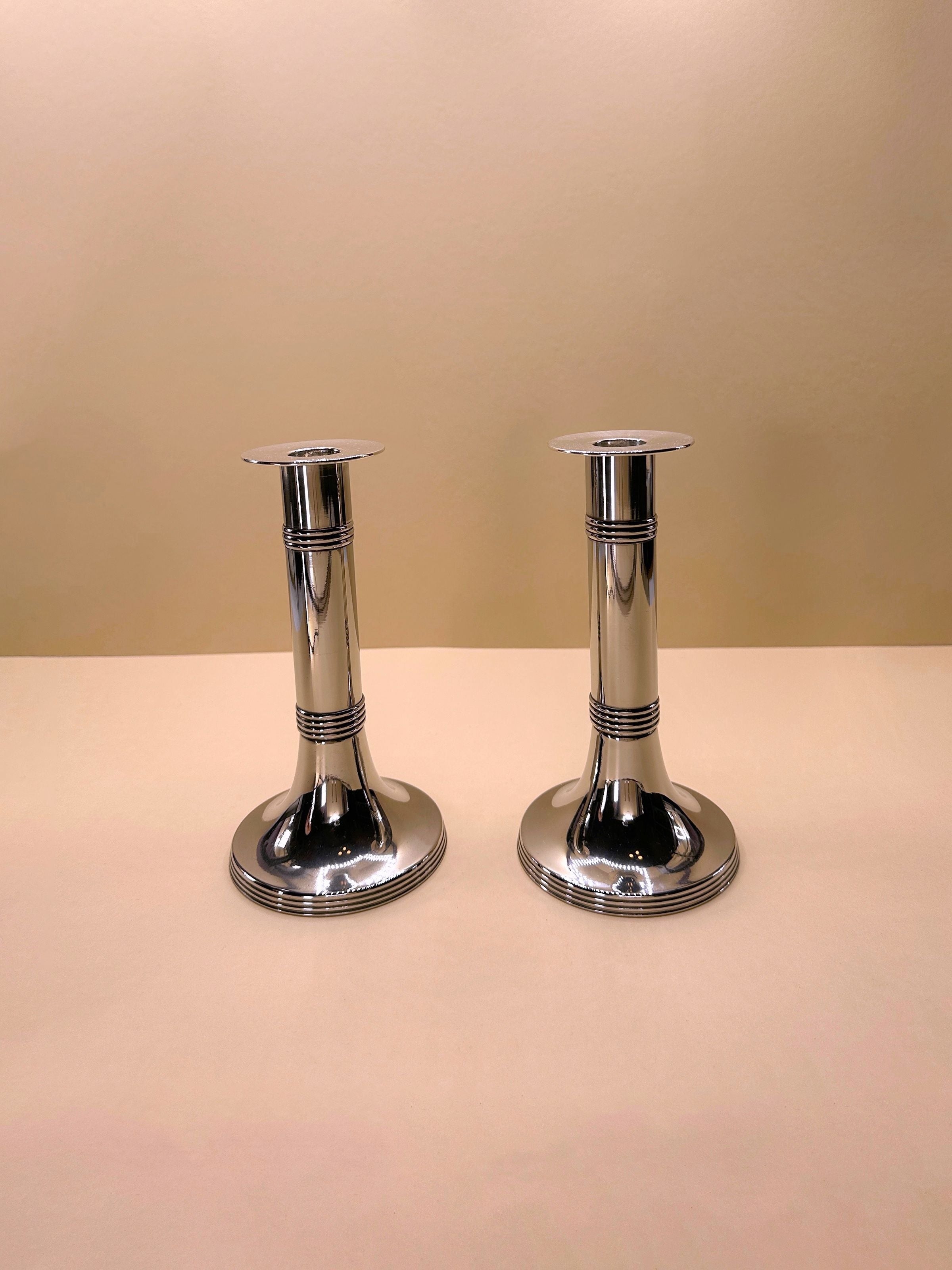 Pair of silver-plated candlesticks by Gunther Lambert, featuring intricate design and elegant curves