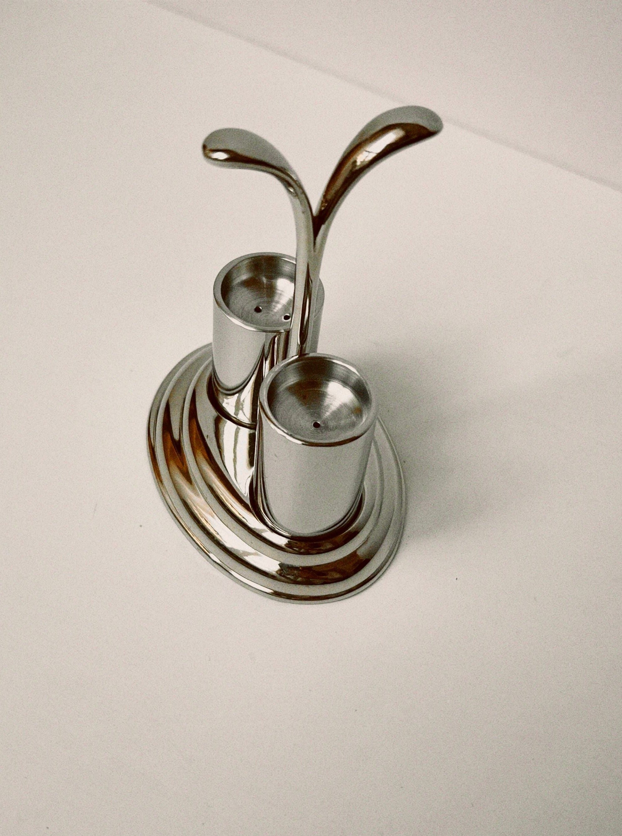 Salt and pepper shakers in silver holder with intricate design