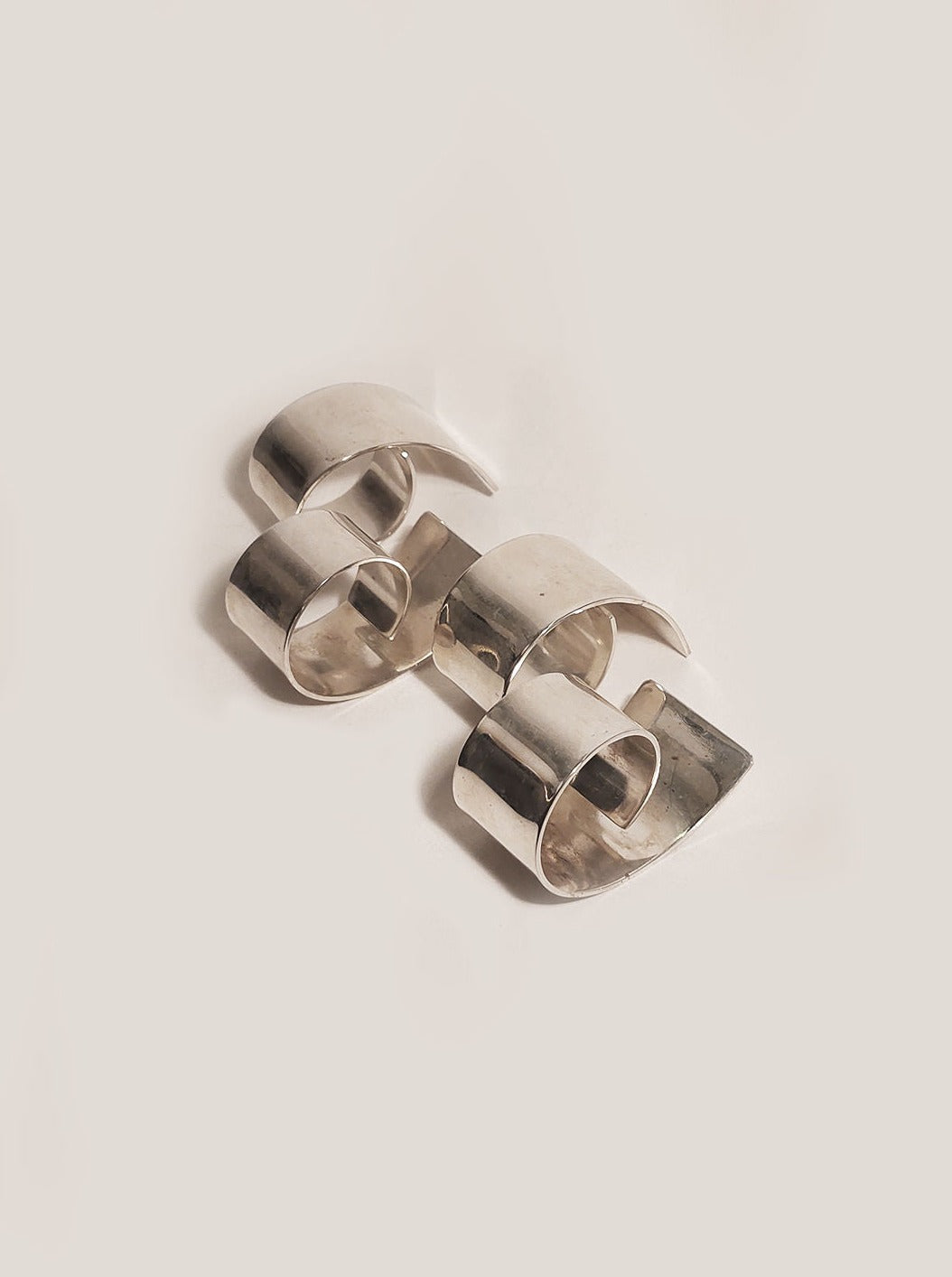 Set of 4 gold-toned napkin rings with floral design