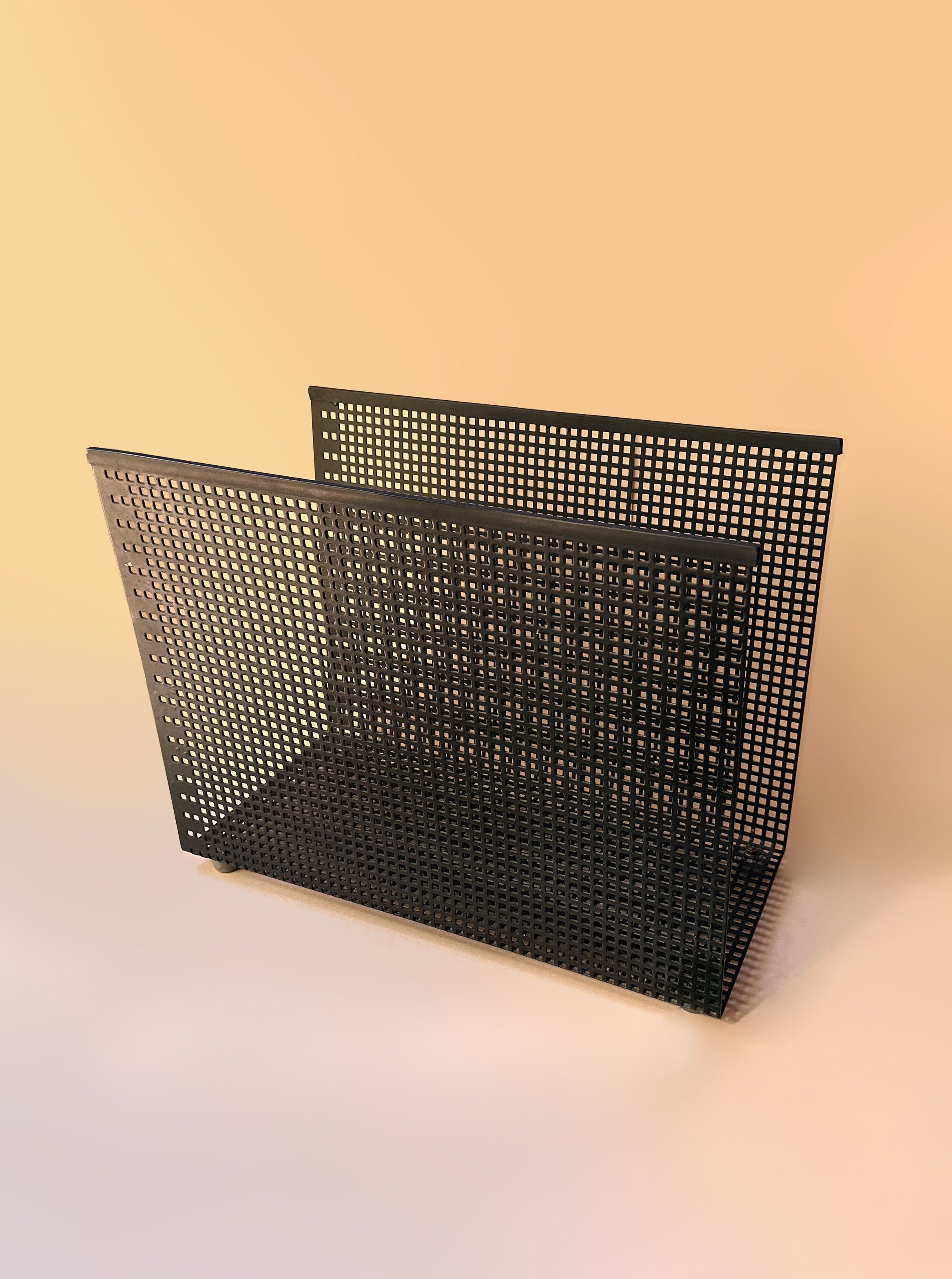 Postmodern black perforated metal magazine rack from the 80s with stylish design