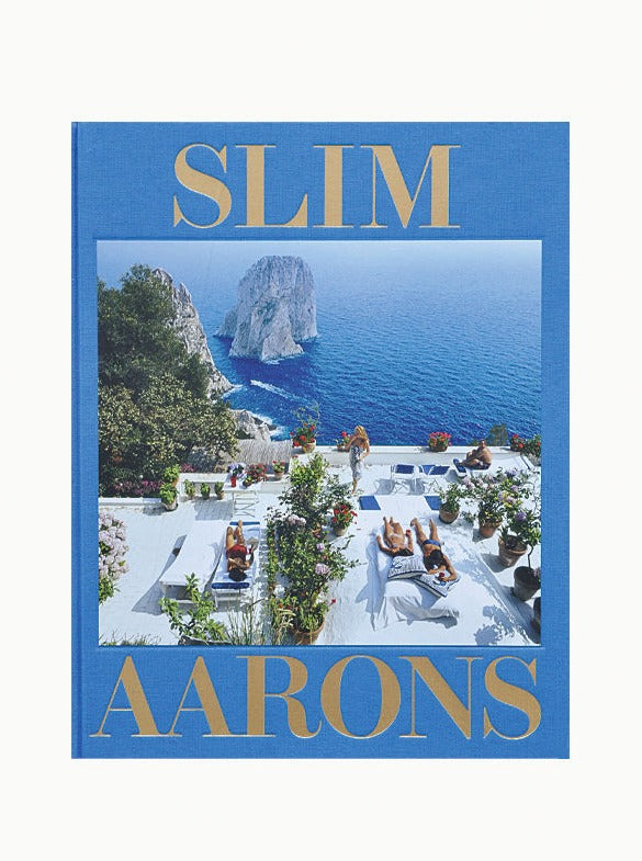 An elegant poolside scene with glamorous people lounging in the sun at a luxurious estate in Slim Aarons: The Essential Collection