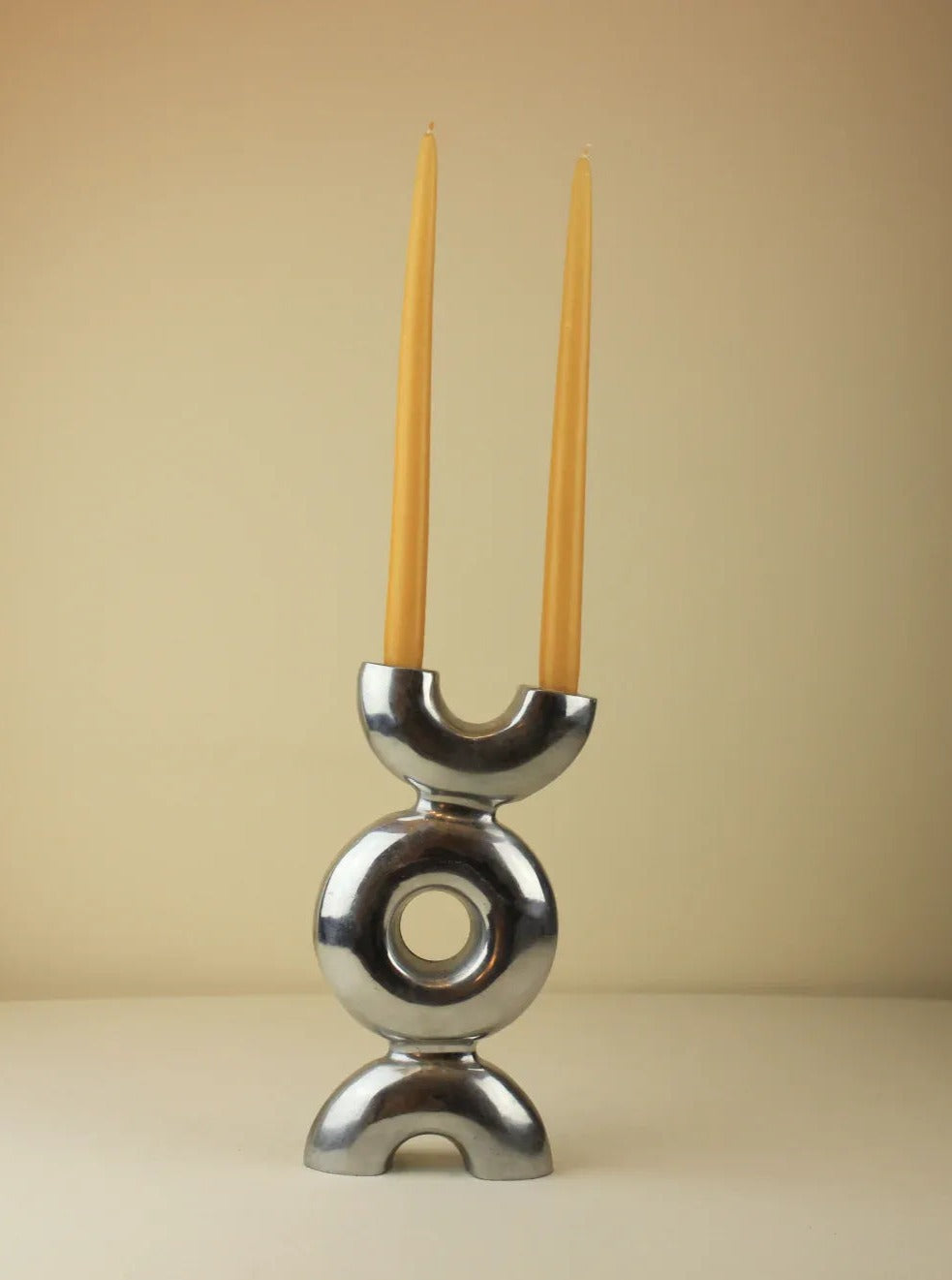 Sculptural candleholder with sleek, modern design and gold finish