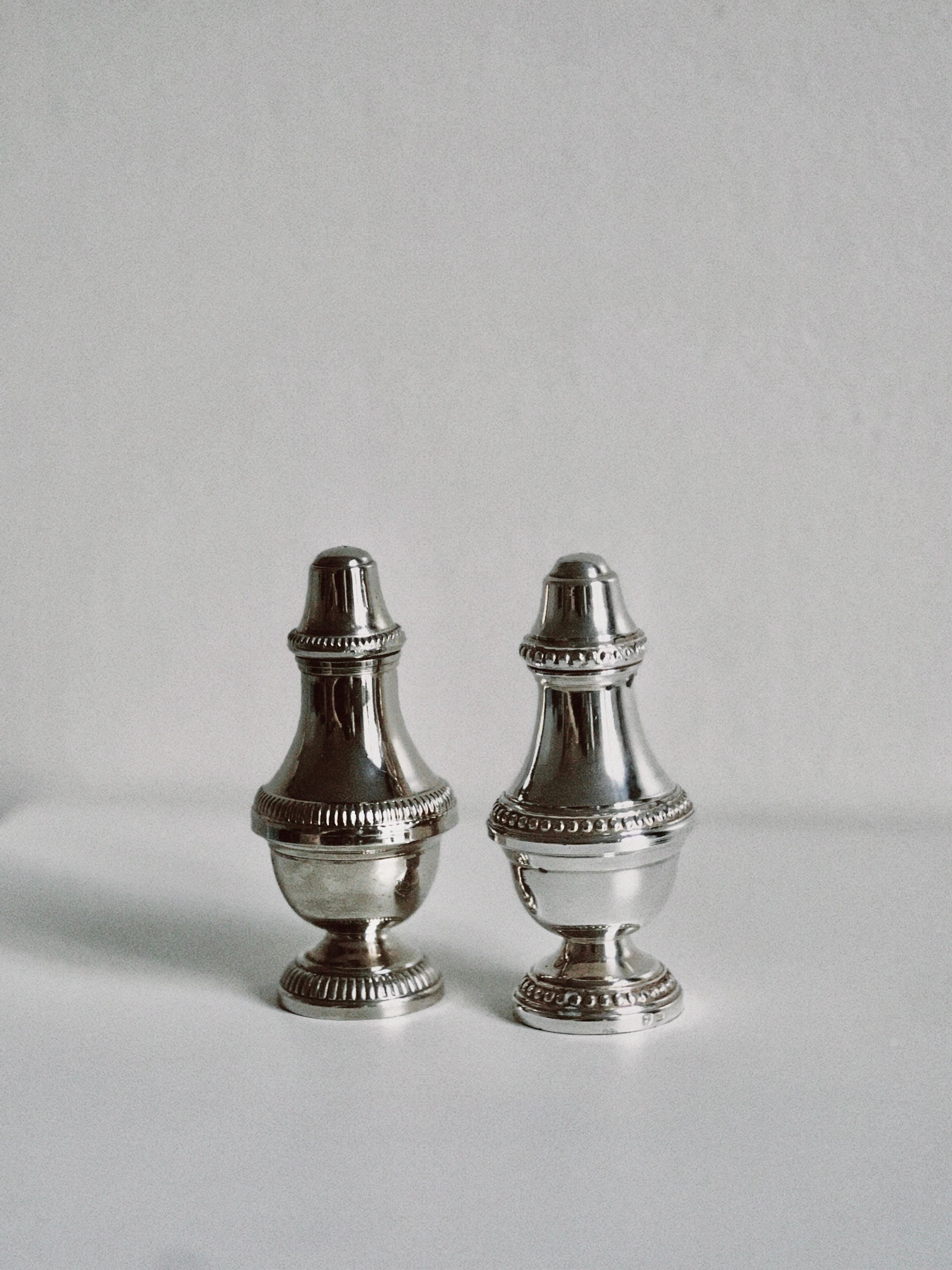 Silver salt and pepper shakers with intricate filigree details and elegant design