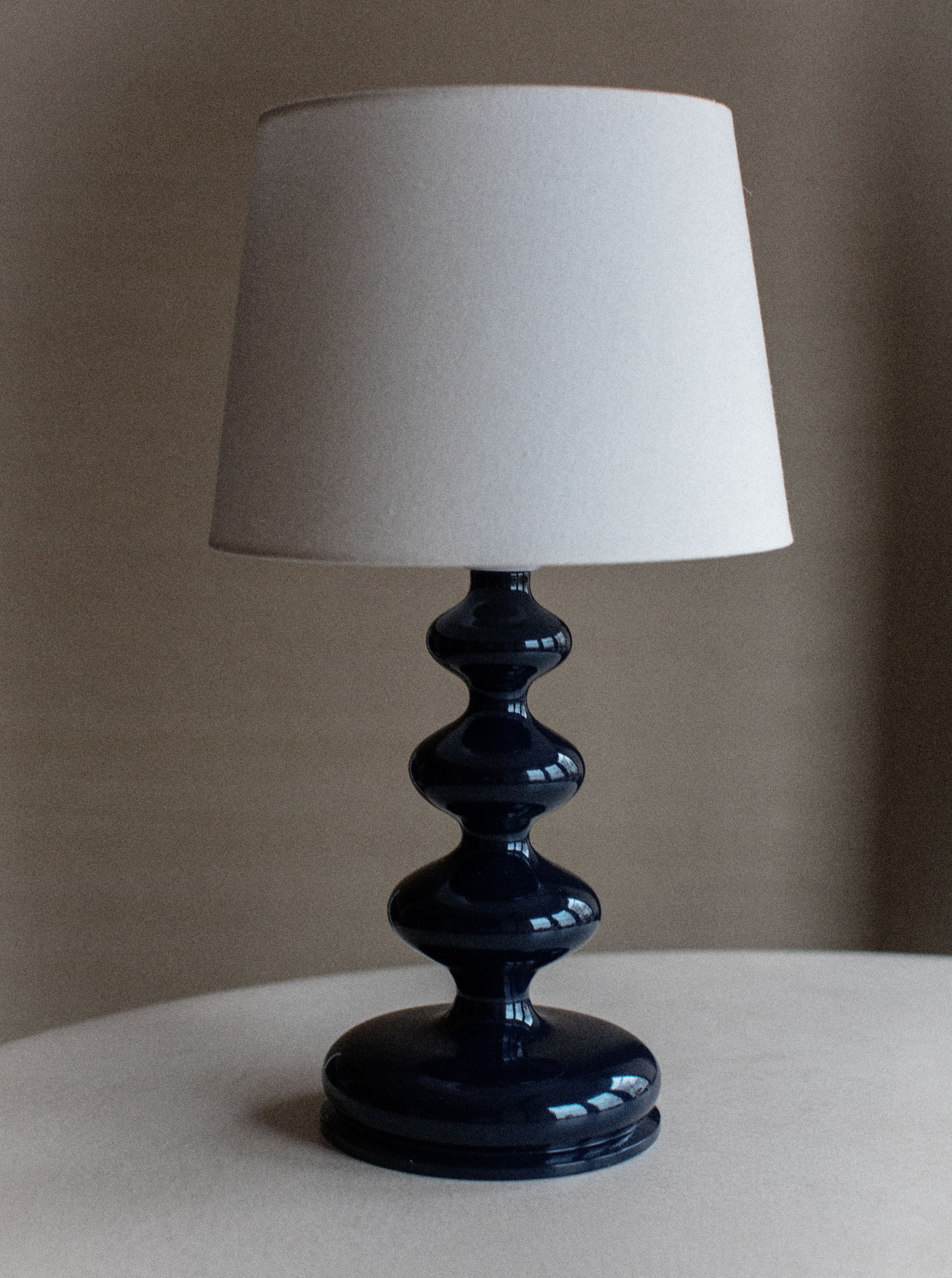 Sculptural lamp with gold geometric base and white fabric shade