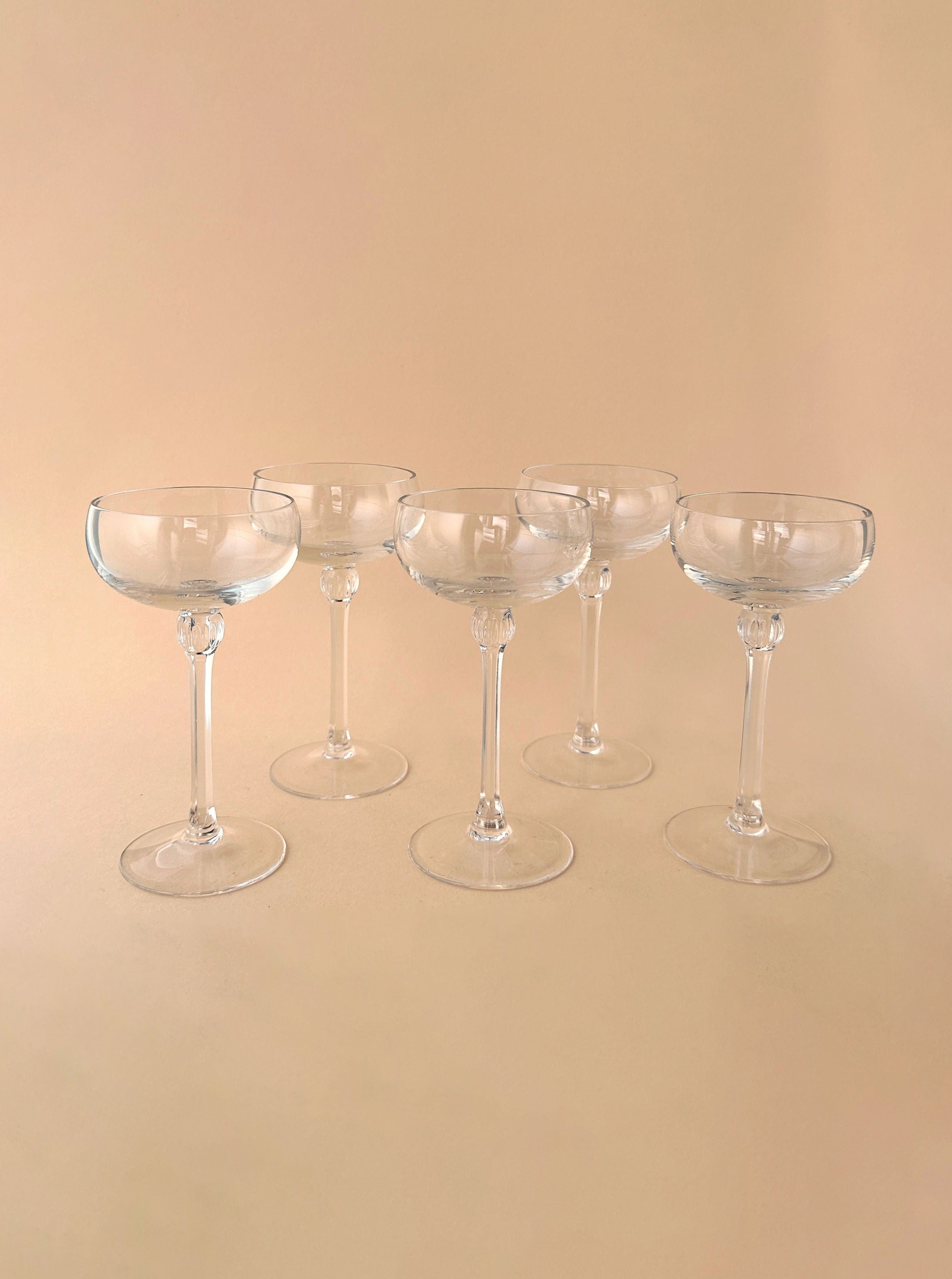 Set of 5 small champagne bowls made of clear glass with delicate rims and elegant design, perfect for serving beverages at special occasions or gatherings