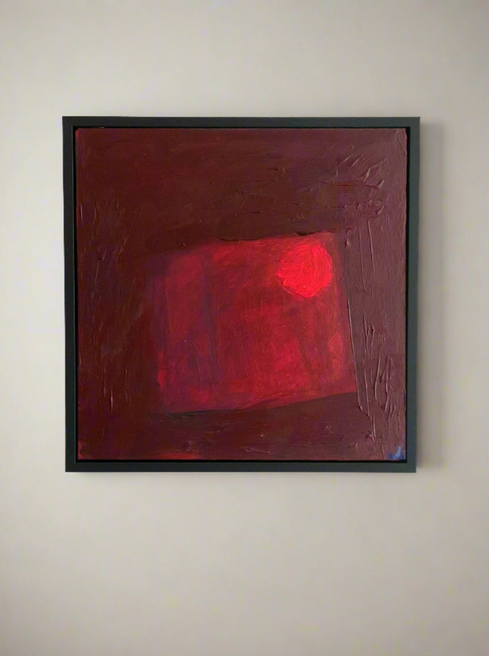 Lara Voce's "Red Sky At Night" is a framed abstract painting featuring deep red and maroon hues in a minimalist design. A textured square center and bright red circle add depth and movement, perfect for enhancing sophistication in any luxury interior.