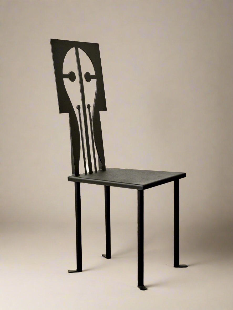 The Epona Chair in Iron and Black Powder Coat from Animate Objects, featuring a unique backrest design that resembles a stylized human head and neck with minimalist facial features, is showcased against a plain white wall on a polished brown floor.