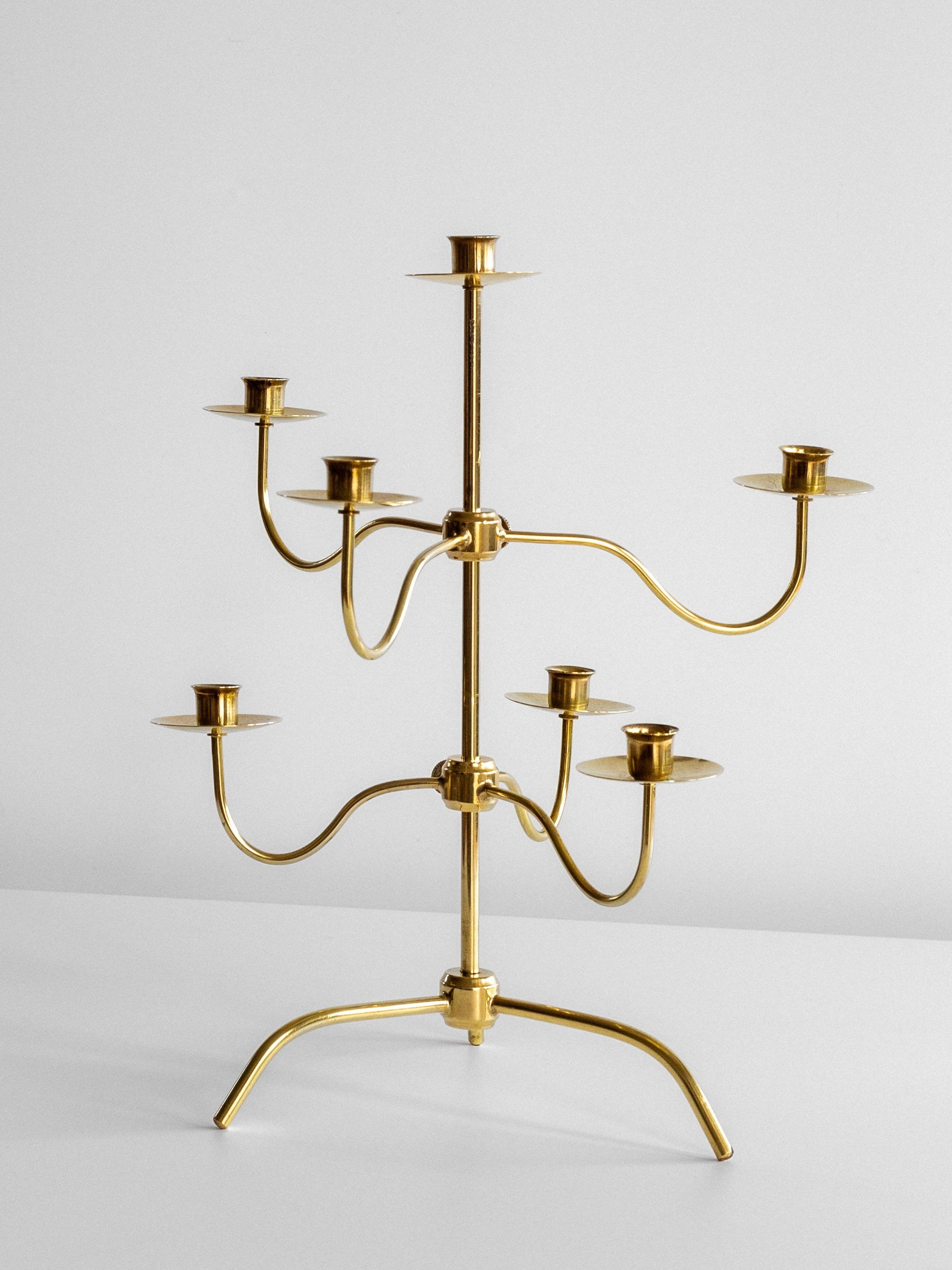 The Spigel Medium Mid-Century Brass Candelabra, featuring eight candle holders arranged on three levels, sits on a white surface against a plain white background. The design, reminiscent of Josef Frank's modern style for Svenskt Tenn, showcases curved arms extending from a central stem.