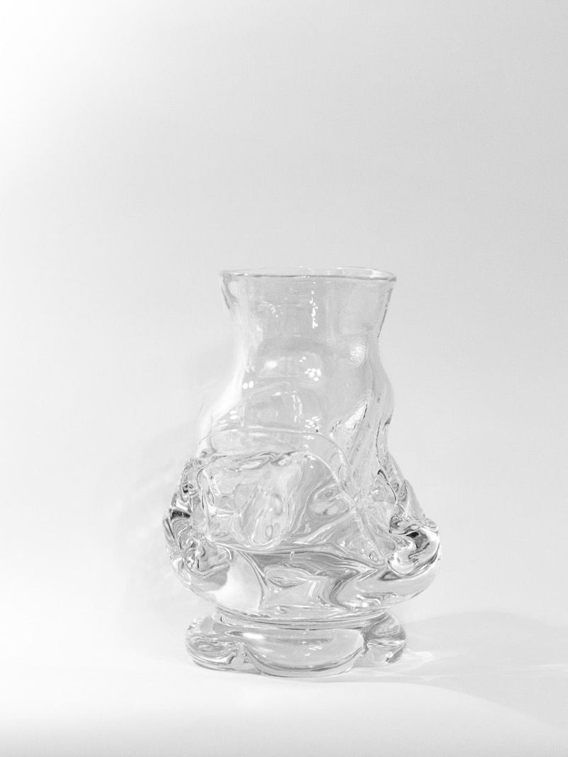 A transparent Free Blown Vase by Szkło Studio, featuring intricate freehand-blown patterns and a wide base, stands against a white background. Made from lead-free glass, it blends artistic and functional design with shadows enhancing its textured surface.