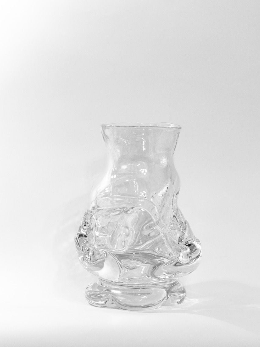 A transparent Free Blown Vase by Szkło Studio, featuring intricate freehand-blown patterns and a wide base, stands against a white background. Made from lead-free glass, it blends artistic and functional design with shadows enhancing its textured surface.