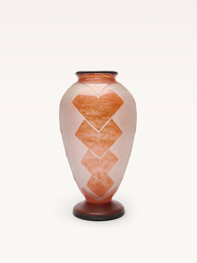 The Galerie MLS Glass Baluster Object is a tall, translucent Art Deco vase with a rounded body, narrow neck, flared rim, and bold orange sandblasted geometric designs on frosted glass. It stands on a small, dark circular base.