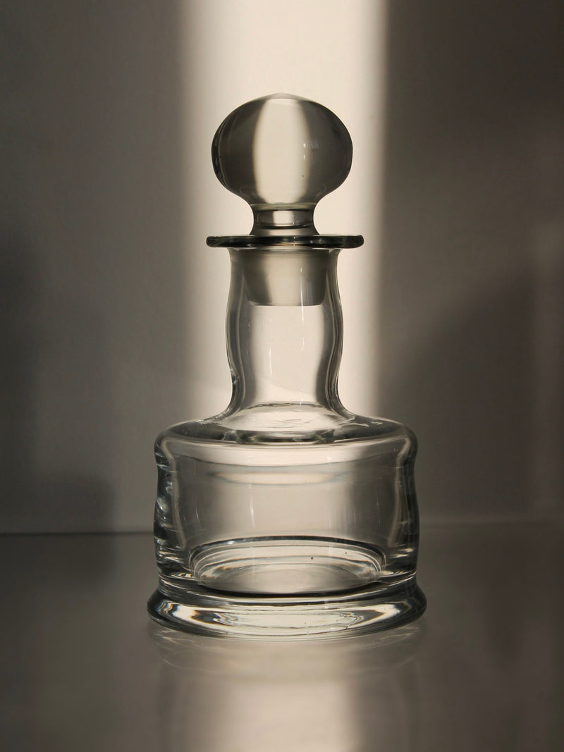 Clear glass mini decanter with rounded stopper and elegant base