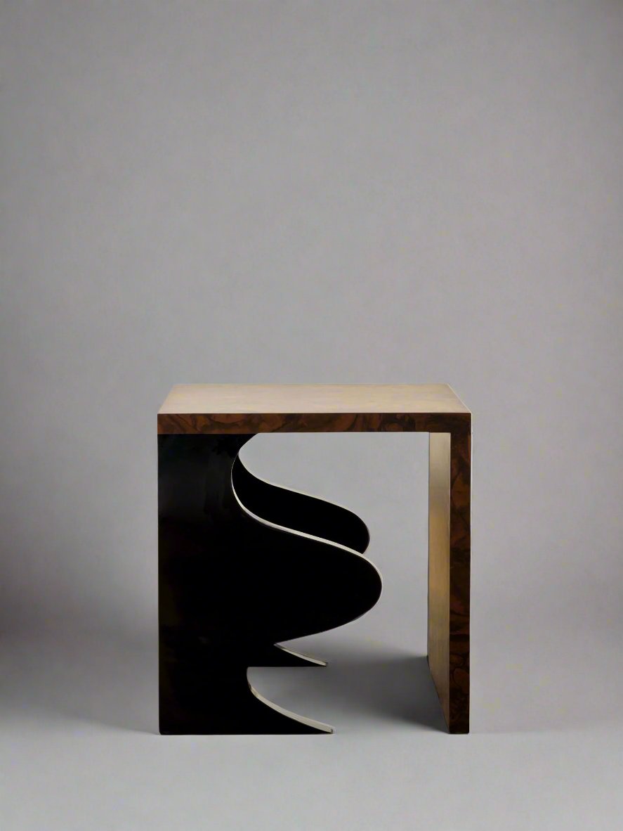 Introducing the Harlequin Side Table by Animate Objects, a limited edition luxury furniture piece that features a sculptural design with an abstract black cutout element. The walnut burl veneer over gloss lacquered wood adds to its sophistication as it gracefully stands on a polished wooden floor against a plain white wall, showcasing its elegant craftsmanship in every handcrafted detail.