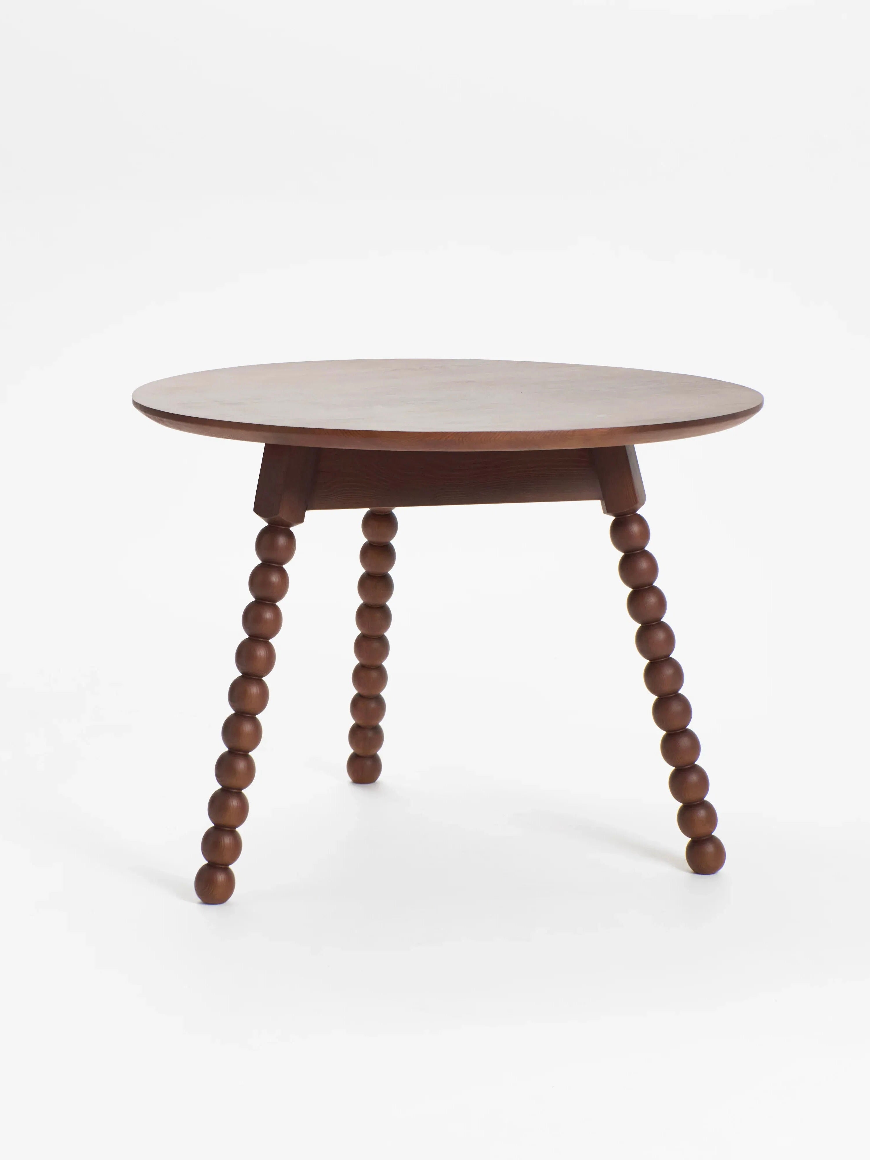 The Project 213A 'Bolha' Table features a charming bistro style with a smooth, round top and three elegantly stacked, turned wood legs. This solid wooden piece stands out beautifully against a plain white backdrop.