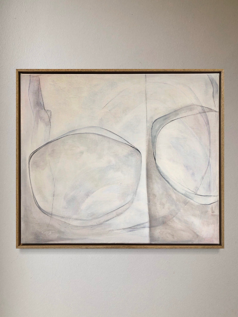 The "Dreams Move Fast 004" painting by Cate Adriana is a minimalist abstract piece featuring two large, rounded shapes outlined in soft gray against a beige background. Rendered in acrylic, the composition is divided into two sections, creating depth and balance. It is simply framed in wood and displayed on a neutral wall.