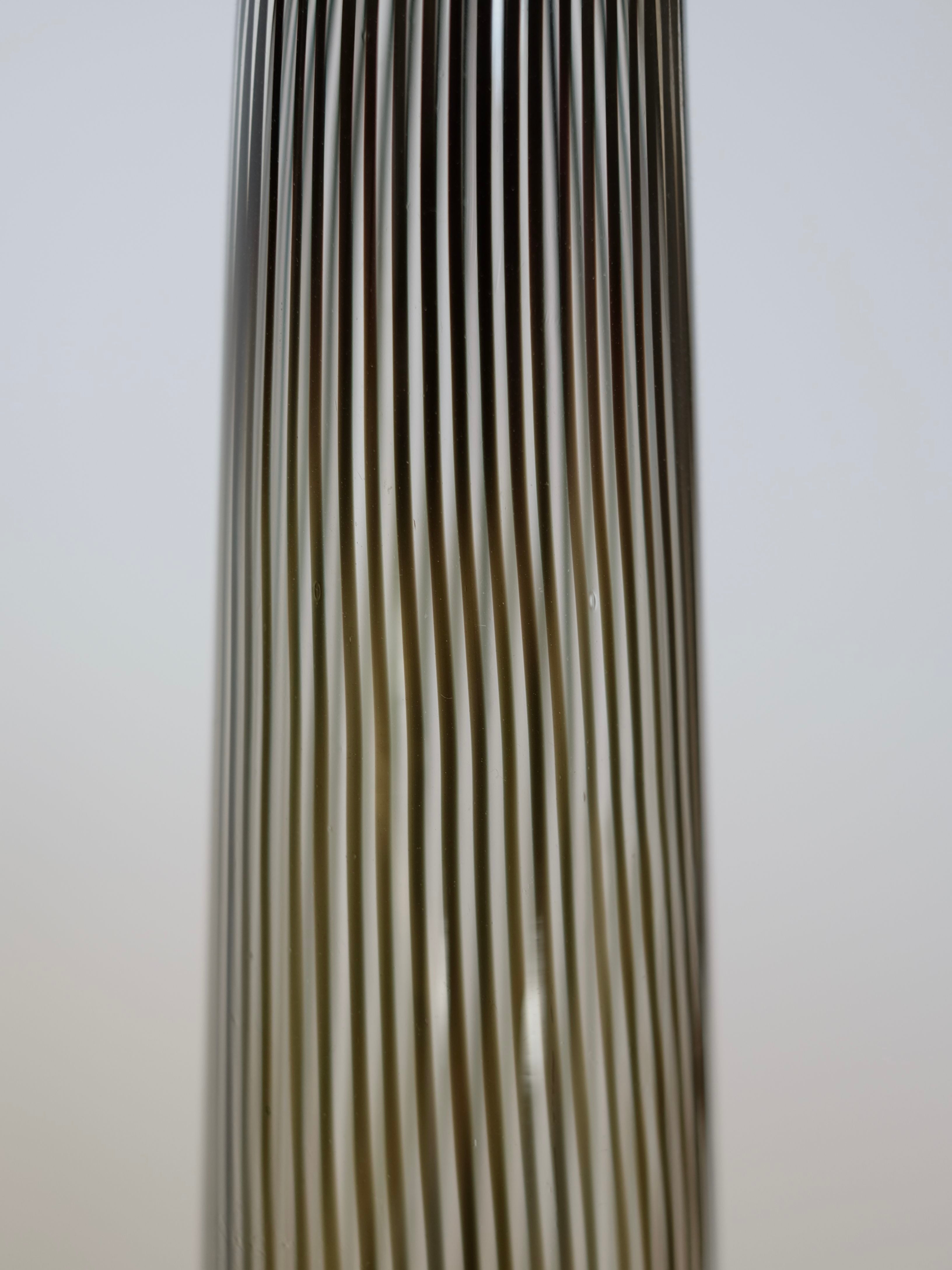 Close-up image of the Italian Murano Vase, a vintage 1970 piece from septembre studios, featuring vertical black and transparent stripes that create an optical illusion effect. The elegant design highlights the sophistication of Italian glasswork against a softly blurred background.