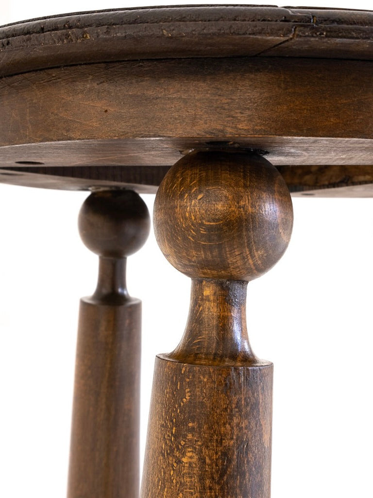 Close-up of a solid oak leg from the 1940s "Set of 2 Chairs and 1 Table" by Charles Dudouyt. The rich brown wood accentuates its grain, while a blurred light background highlights the expertly restored antibeige furniture.