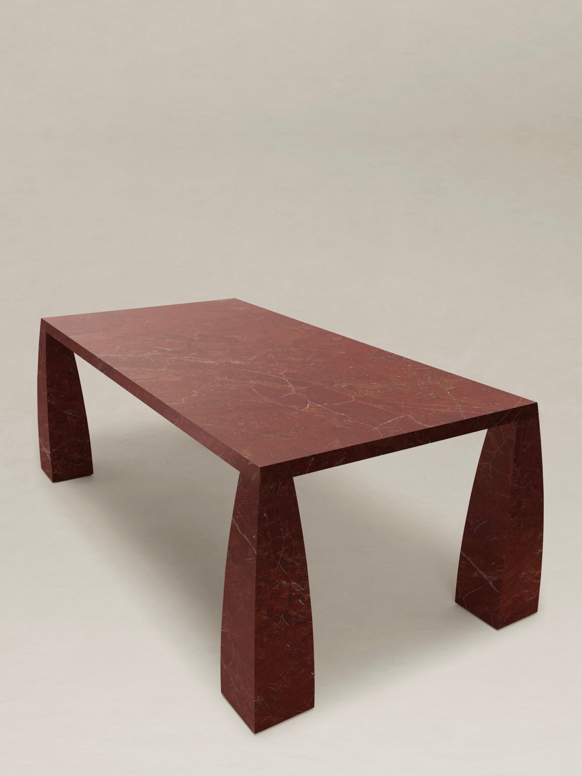 A dining table from AÈDE Studios, known as the "Khram," features a brown marbled rectangular top with sleek, curved legs and a subtle trapezoidal design; it stands gracefully on a plain, light-colored floor. Its polished, glossy surface exudes an elegance reminiscent of traditional Russian architecture.