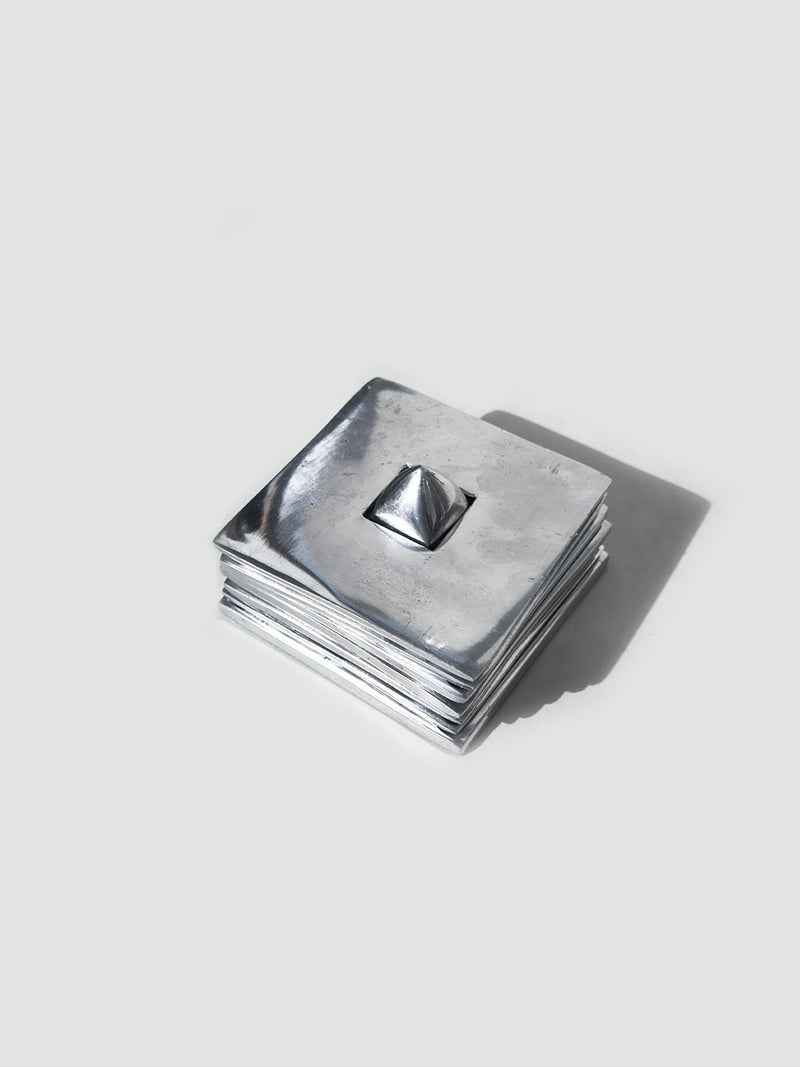 Set of 6 stackable silver metal coasters with pyramid center detail