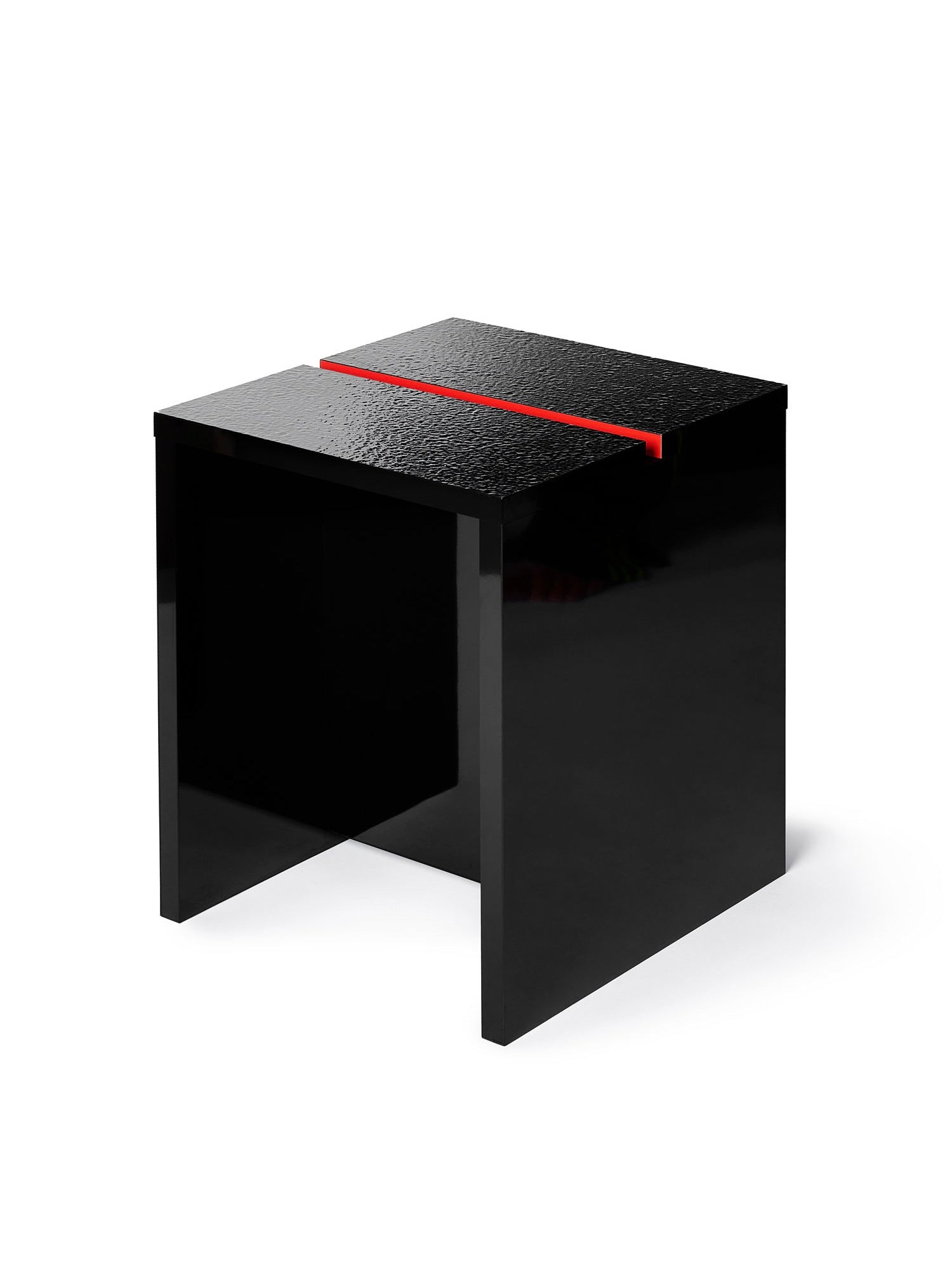 A modern, glossy side table in Wet Black by TEGET, akin to the Mara Gap Stool, features a textured surface with a central red groove. Its minimalist design and clean lines make it ideal for those who love customizable furniture options.