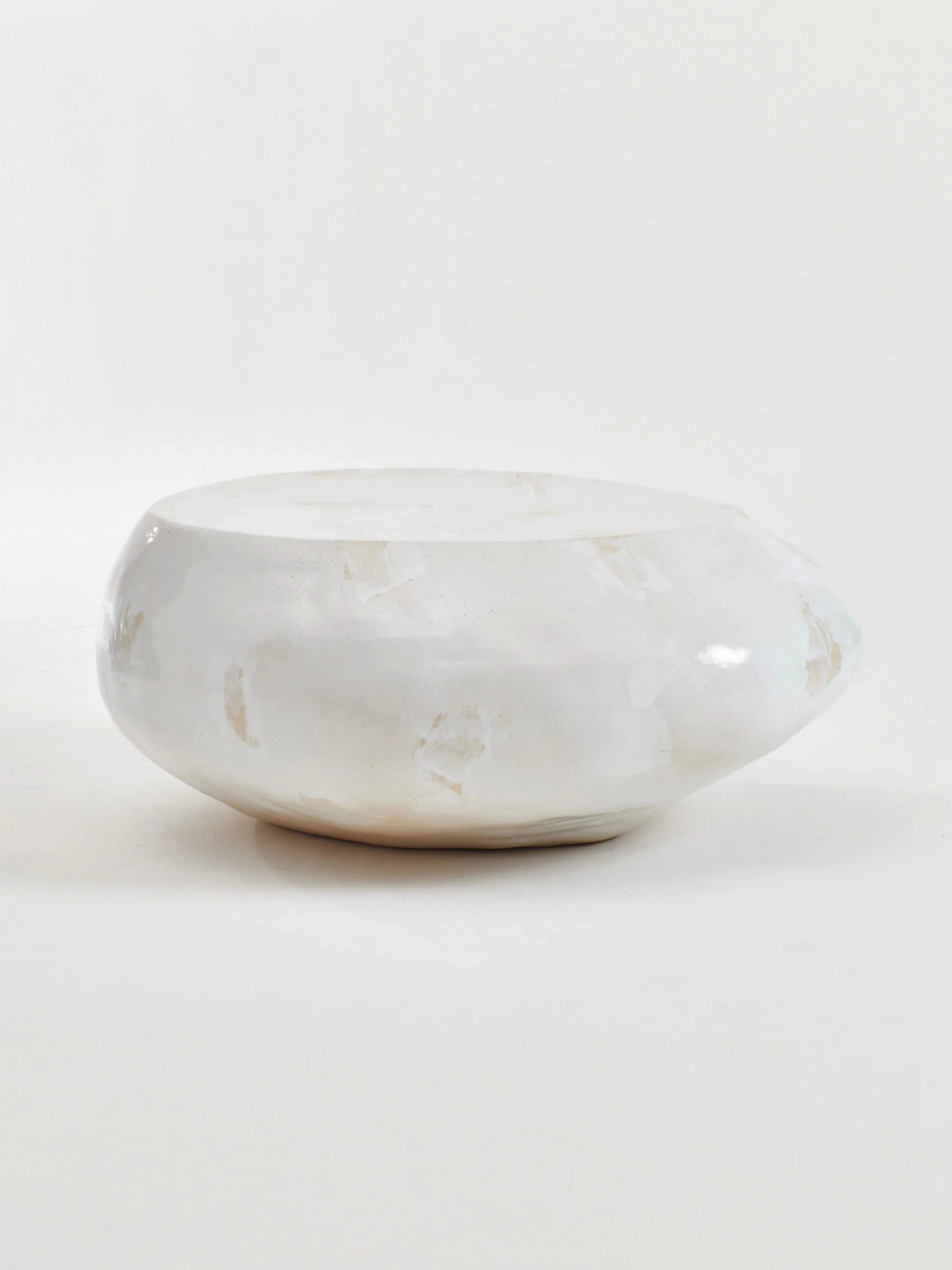 A round, cream-colored ceramic coffee table with a slightly textured surface and a glossy finish sits on a plain white background. The handmade construction from Project 213A showcases its wide top and shallow depth, lending it a minimalist and modern appearance.