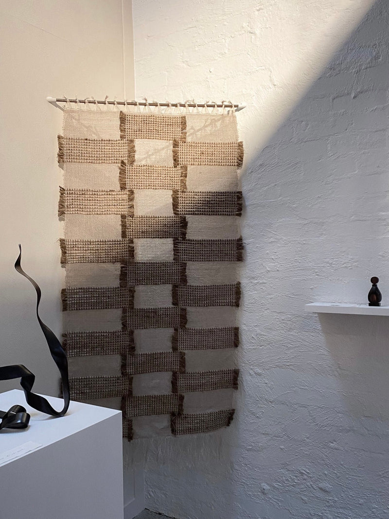 Woven textile wall hanging with geometric checkerboard pattern