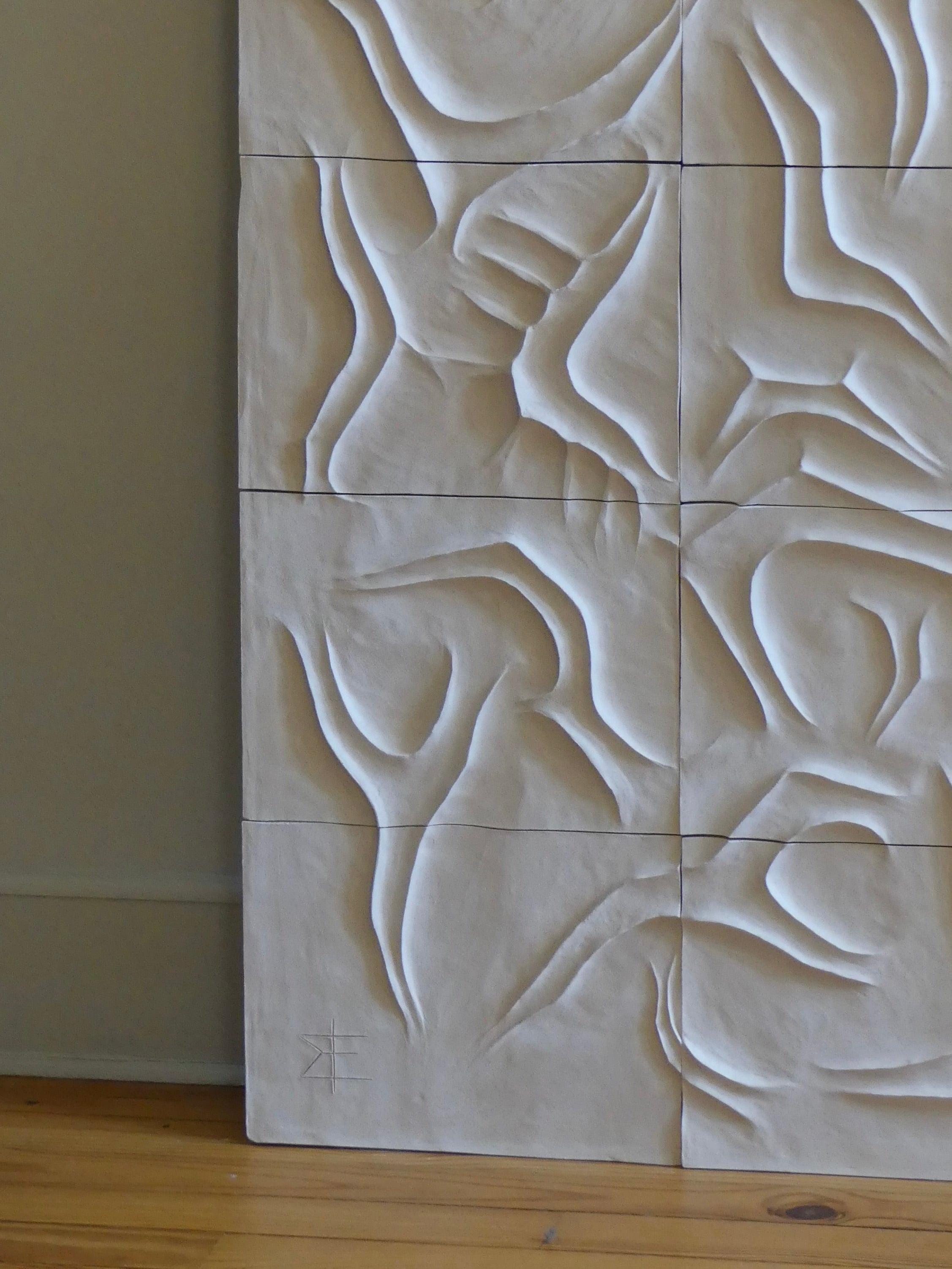 The Scala Dei Turchi Wall Sculpture by Franck Scala features textured white panels with abstract bas-relief designs, seamlessly creating a flowing, organic pattern on neutral-colored walls complemented by wooden floors.