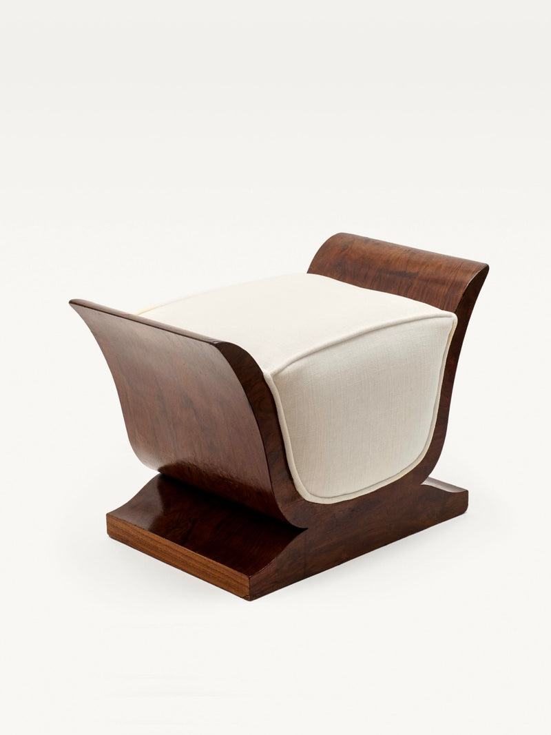 The Art Deco Stool by Galerie MLS features curved, lyre-shaped sides and an off-white rectangular upholstered seat on a flat walnut 1930s-style base, shown against a plain white background.