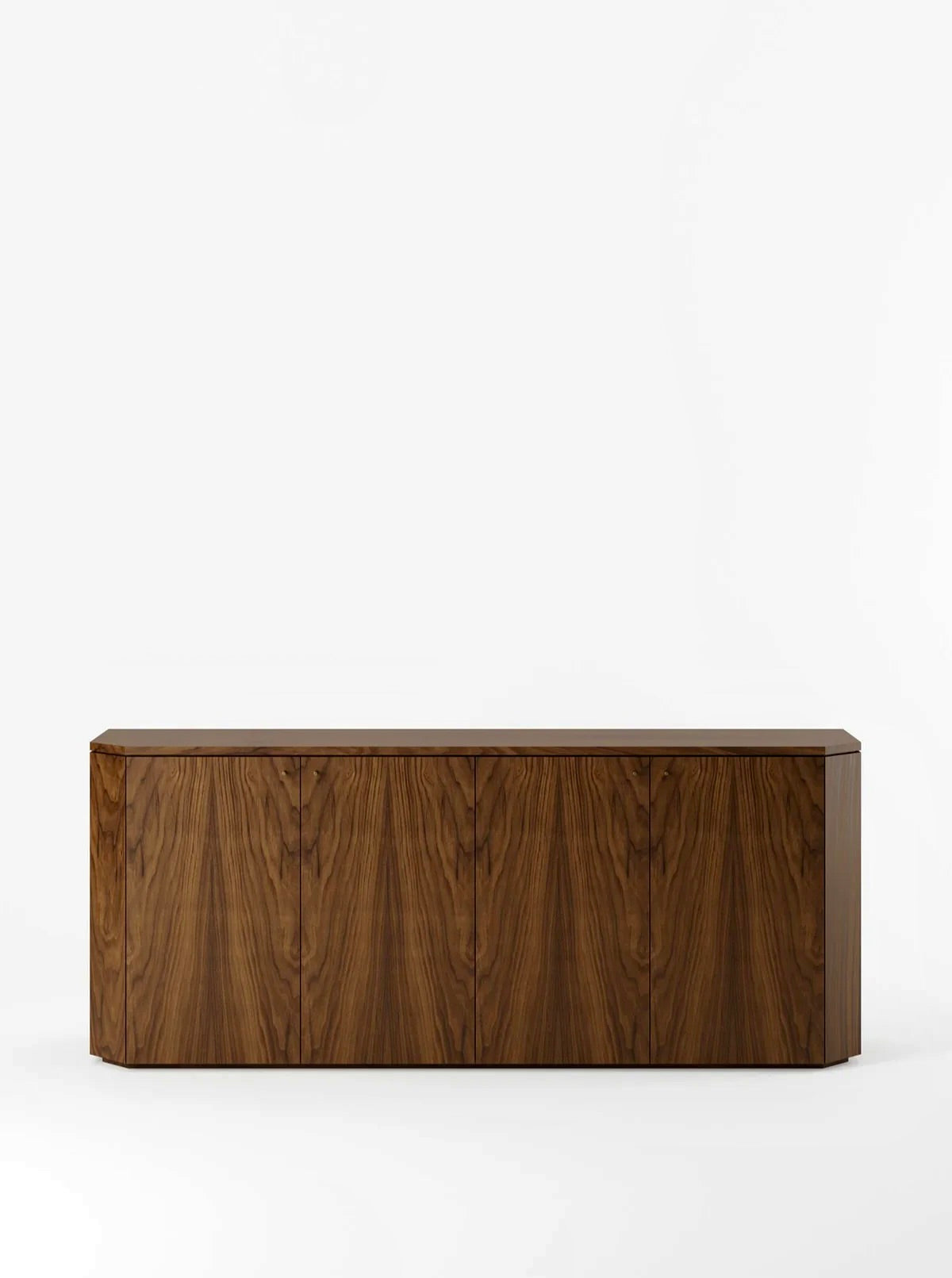 The Winston Server in Walnut by Lemon is a modern, rectangular wooden sideboard with a minimalist design. Created by Italian designer Franca Helg, it has four cabinet doors displaying a symmetrical wood grain pattern. The sideboard features a smooth finish and no handles, contributing to its sleek, contemporary look against a plain white background.