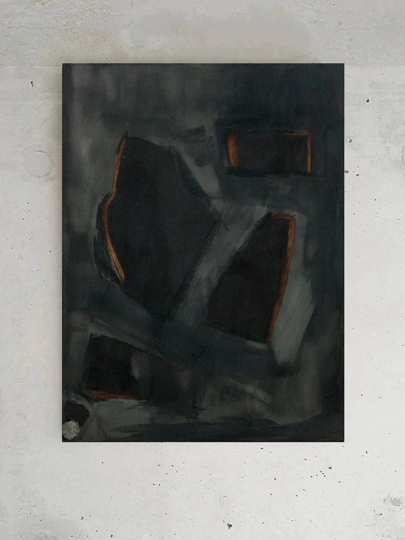 An artwork titled "Complex Hue's in G Minor" by Yeliza Gevorgyan, showcasing dark abstract forms highlighted with accents of orange on a textured gray background, elegantly ensconced in an Italian oak frame against a light gray wall.