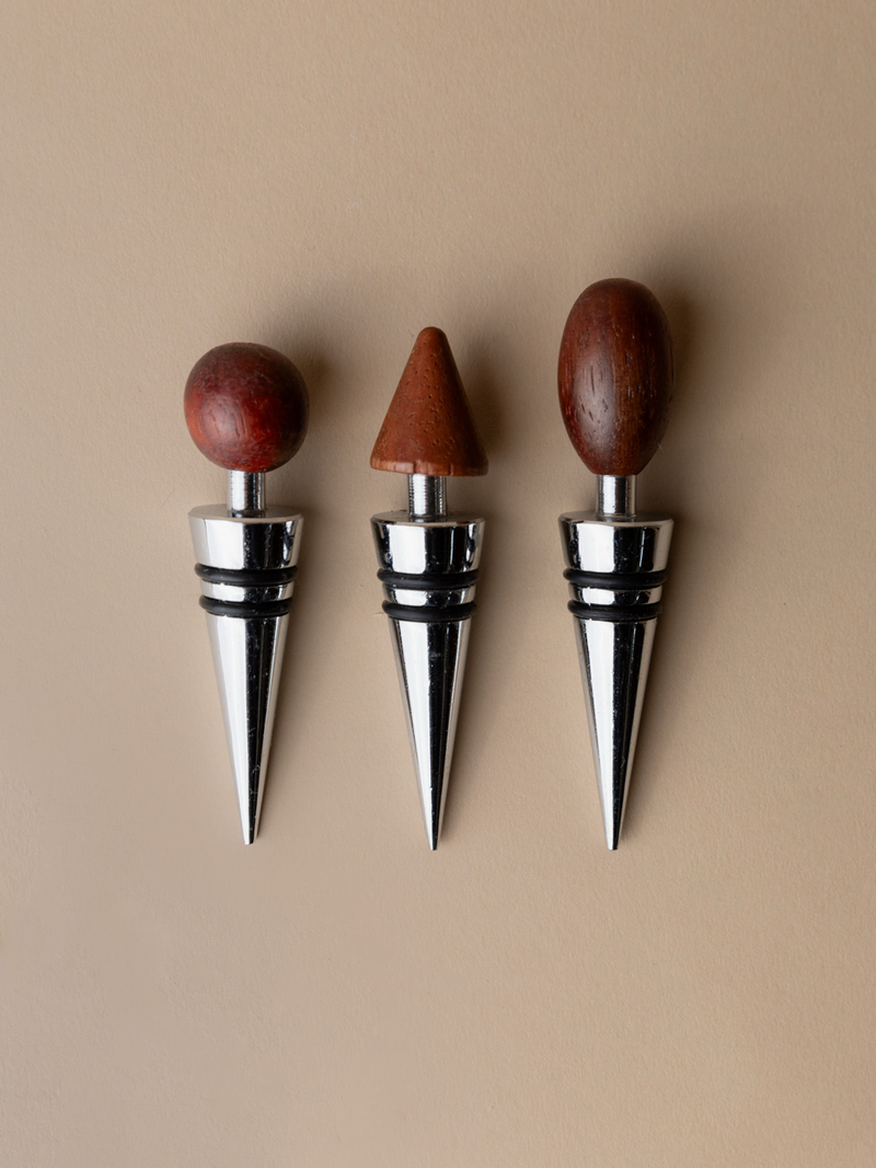 The Bottega Jacobs 3 Bottle Stoppers, Mid Century Italy 1980s, feature wooden handles in round, cone, and oval shapes—stylish wine accessories displayed vertically on a beige background for any collector.