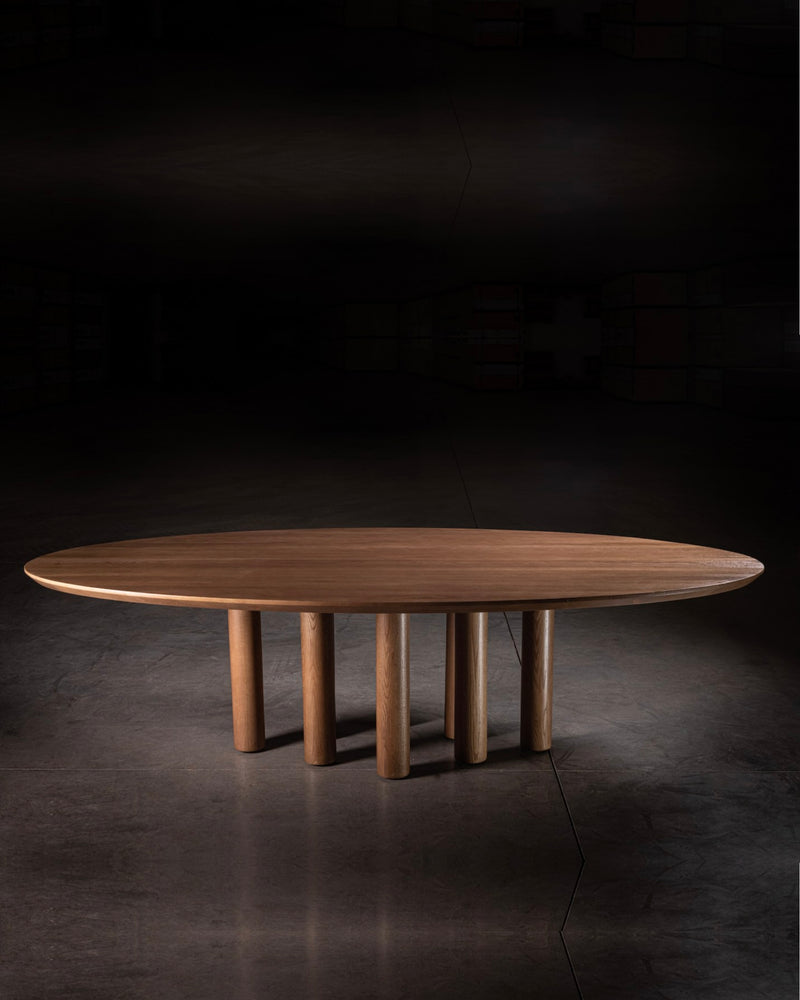 Oval walnut dining table with cylindrical wooden legs by No Age Studio